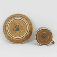 デンマークを代表するデザイナー、イェンス・H・クイストゴーによる「Relief（レリーフ）」シリーズのヴィンテージカップ&ソーサーです。マットなベージュ釉薬に丹念に浮かび上がる葉や木々の〈レリーフ〉装飾が印象的です。素朴で温もりある厚みのあるフォルムは、北欧の静かな森の風景を感じさせます。デンマークではスウェーデンやフィンランドの陶器メーカーと並んで今でも非常に人気のある商品となります。