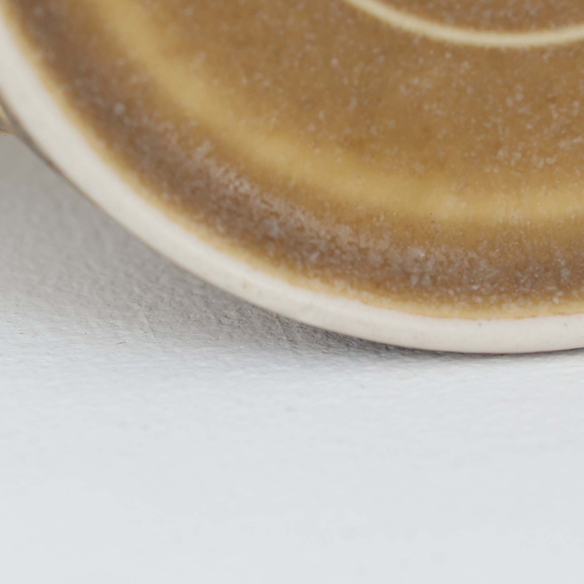 デンマークを代表するデザイナー、イェンス・H・クイストゴーによる「Relief（レリーフ）」シリーズのヴィンテージカップ&ソーサーです。マットなベージュ釉薬に丹念に浮かび上がる葉や木々の〈レリーフ〉装飾が印象的です。素朴で温もりある厚みのあるフォルムは、北欧の静かな森の風景を感じさせます。デンマークではスウェーデンやフィンランドの陶器メーカーと並んで今でも非常に人気のある商品となります。