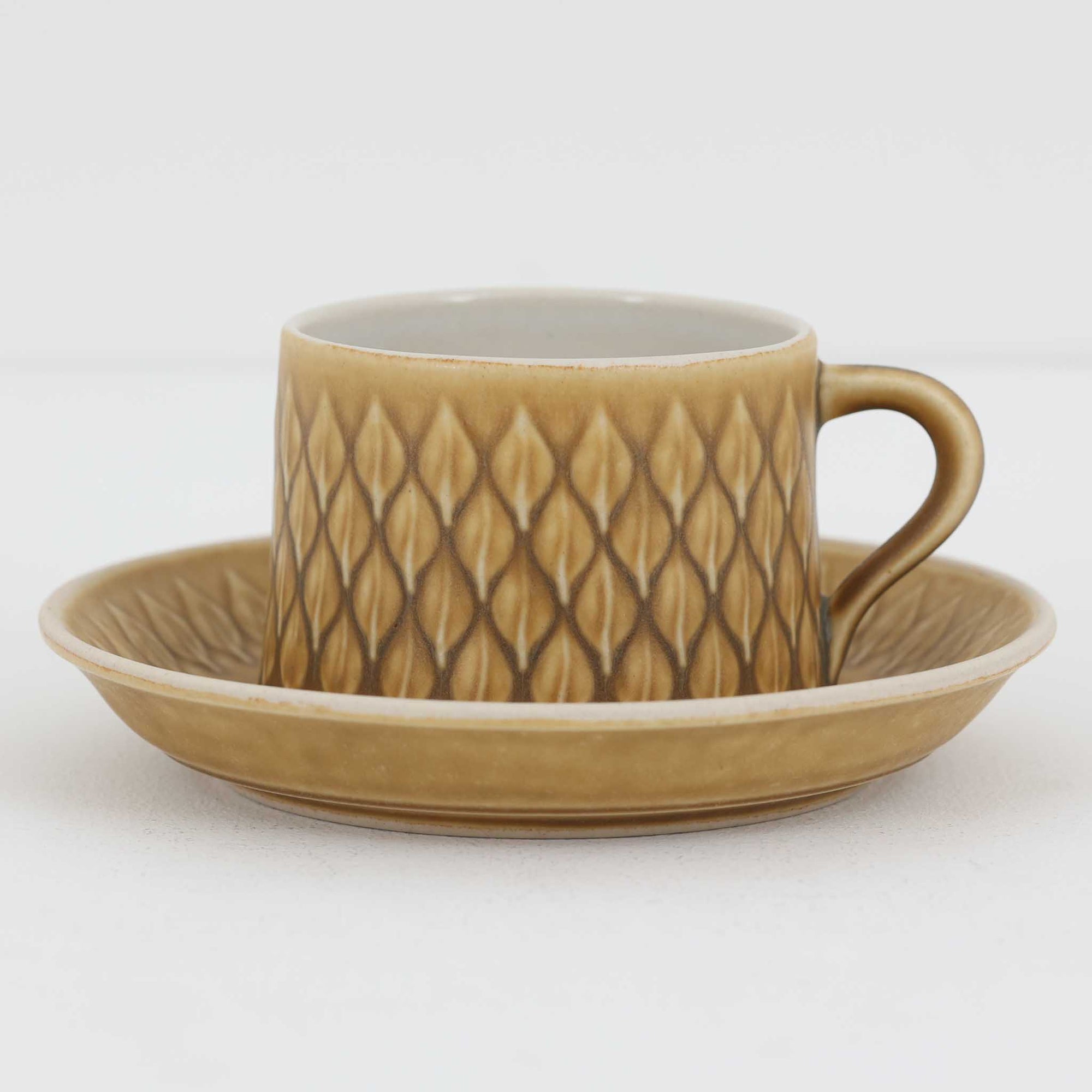 デンマークを代表するデザイナー、イェンス・H・クイストゴーによる「Relief（レリーフ）」シリーズのヴィンテージカップ&ソーサーです。マットなベージュ釉薬に丹念に浮かび上がる葉や木々の〈レリーフ〉装飾が印象的です。素朴で温もりある厚みのあるフォルムは、北欧の静かな森の風景を感じさせます。デンマークではスウェーデンやフィンランドの陶器メーカーと並んで今でも非常に人気のある商品となります。