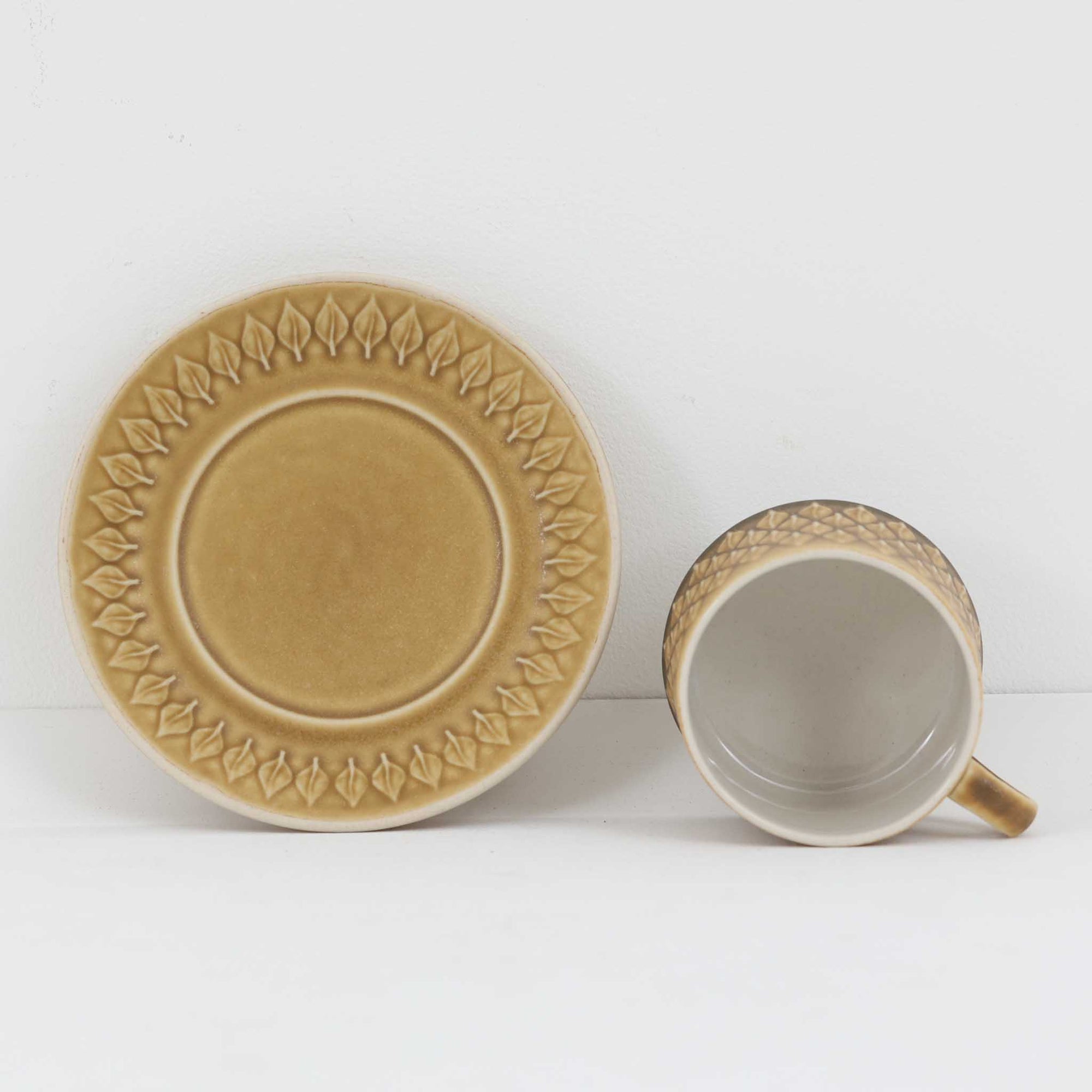 デンマークを代表するデザイナー、イェンス・H・クイストゴーによる「Relief（レリーフ）」シリーズのヴィンテージカップ&amp;ソーサーです。マットなベージュ釉薬に丹念に浮かび上がる葉や木々の〈レリーフ〉装飾が印象的です。素朴で温もりある厚みのあるフォルムは、北欧の静かな森の風景を感じさせます。デンマークではスウェーデンやフィンランドの陶器メーカーと並んで今でも非常に人気のある商品となります。