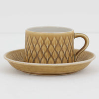 デンマークを代表するデザイナー、イェンス・H・クイストゴーによる「Relief（レリーフ）」シリーズのヴィンテージカップ&ソーサーです。マットなベージュ釉薬に丹念に浮かび上がる葉や木々の〈レリーフ〉装飾が印象的です。素朴で温もりある厚みのあるフォルムは、北欧の静かな森の風景を感じさせます。デンマークではスウェーデンやフィンランドの陶器メーカーと並んで今でも非常に人気のある商品となります。