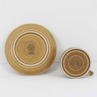 デンマークを代表するデザイナー、イェンス・H・クイストゴーによる「Relief（レリーフ）」シリーズのヴィンテージカップ&ソーサーです。マットなベージュ釉薬に丹念に浮かび上がる葉や木々の〈レリーフ〉装飾が印象的です。素朴で温もりある厚みのあるフォルムは、北欧の静かな森の風景を感じさせます。デンマークではスウェーデンやフィンランドの陶器メーカーと並んで今でも非常に人気のある商品となります。