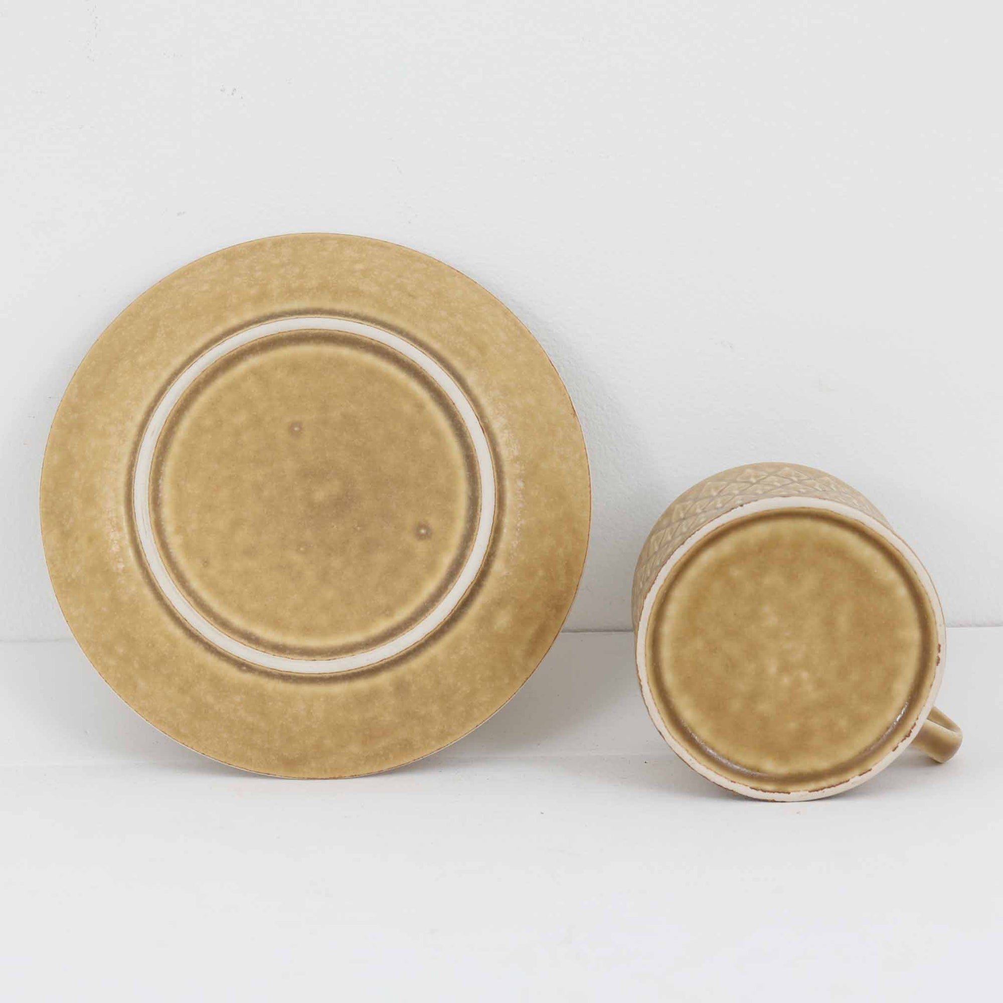 デンマークを代表するデザイナー、イェンス・H・クイストゴーによる「Relief（レリーフ）」シリーズのヴィンテージカップ&amp;ソーサーです。マットなベージュ釉薬に丹念に浮かび上がる葉や木々の〈レリーフ〉装飾が印象的です。素朴で温もりある厚みのあるフォルムは、北欧の静かな森の風景を感じさせます。デンマークではスウェーデンやフィンランドの陶器メーカーと並んで今でも非常に人気のある商品となります。