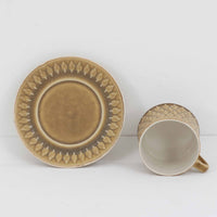 デンマークを代表するデザイナー、イェンス・H・クイストゴーによる「Relief（レリーフ）」シリーズのヴィンテージカップ&ソーサーです。マットなベージュ釉薬に丹念に浮かび上がる葉や木々の〈レリーフ〉装飾が印象的です。素朴で温もりある厚みのあるフォルムは、北欧の静かな森の風景を感じさせます。デンマークではスウェーデンやフィンランドの陶器メーカーと並んで今でも非常に人気のある商品となります。