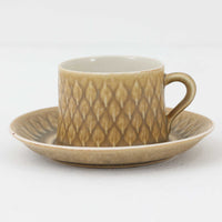 デンマークを代表するデザイナー、イェンス・H・クイストゴーによる「Relief（レリーフ）」シリーズのヴィンテージカップ&ソーサーです。マットなベージュ釉薬に丹念に浮かび上がる葉や木々の〈レリーフ〉装飾が印象的です。素朴で温もりある厚みのあるフォルムは、北欧の静かな森の風景を感じさせます。デンマークではスウェーデンやフィンランドの陶器メーカーと並んで今でも非常に人気のある商品となります。