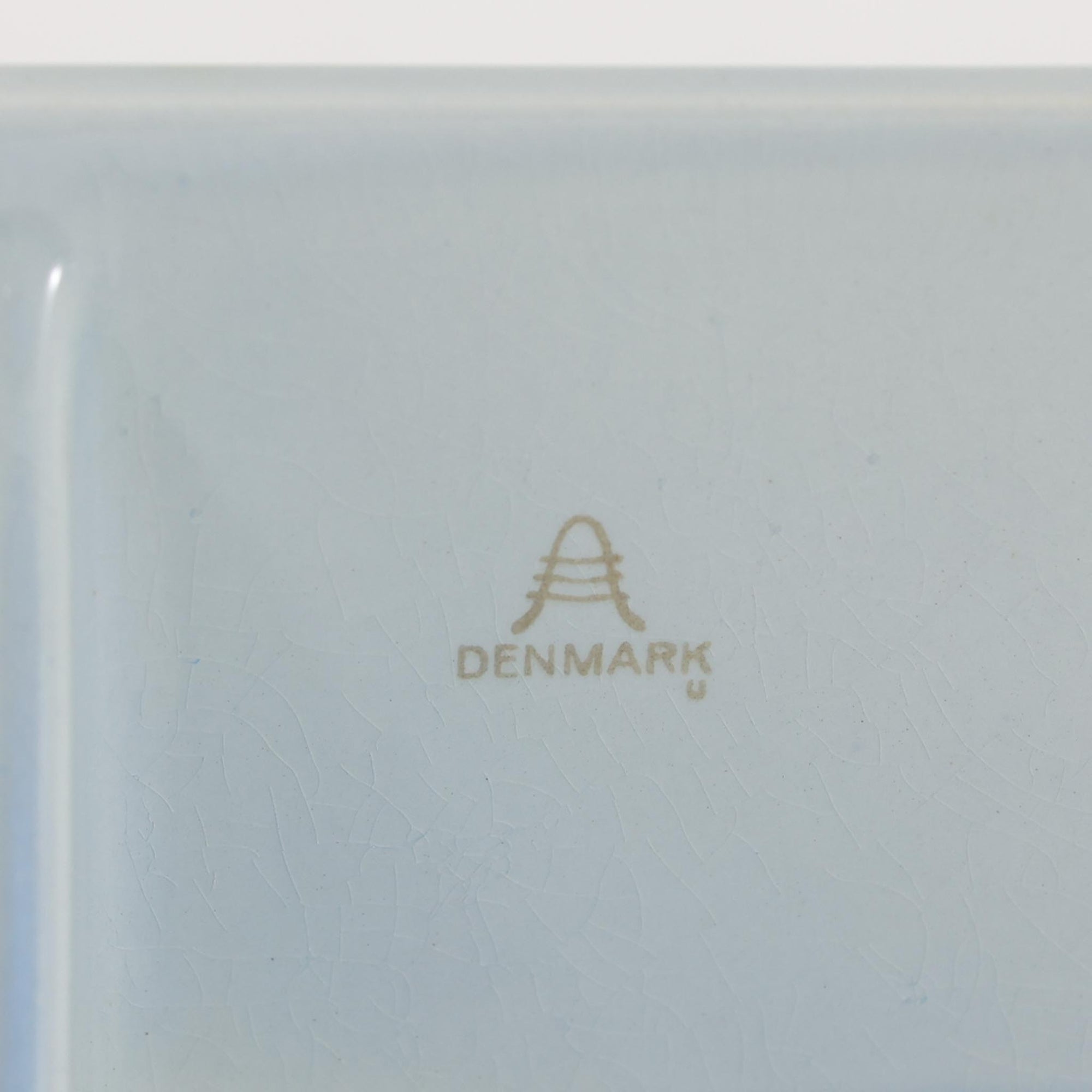 ロイヤルコペンハーゲンの「Tenera」シリーズは、1958年に誕生し1969年以降はRoyal Copenhagenブランドとして展開された、北欧モダンを象徴するファイアンスの名作です。このシリーズの魅力は、アーティスティック・ディレクターのニルス・トーソンが生み出したフォルムに、そこで活躍した女性デザイナーたち（マリアンヌ・ジョンソンやグレーテ・ヘランド＝ハンセン、カリ・クリステンセンなど）が手がけた手描きの大胆で鮮やかな絵付けが融合している点にあります。手仕事ゆえの微妙な色ムラやクラック（クレイジング）は経年変化として味わい深く、花を一輪挿すだけでリビングやダイニングに北欧ならではの温かみとモダンな華やかさを添えます。コレクターはもちろん、日常のインテリアに上質な彩りをプラスしたい方にもおすすめの逸品です。