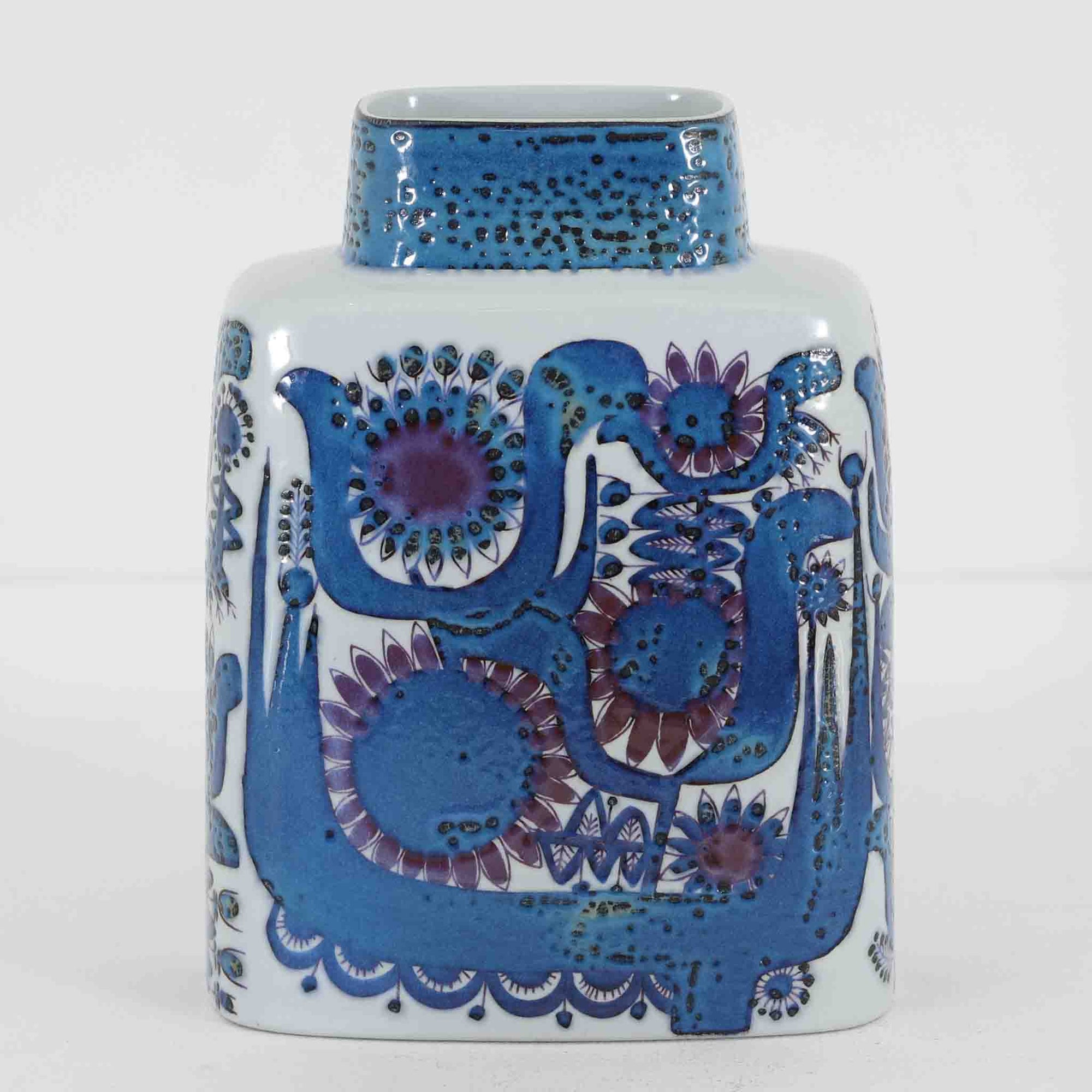 ロイヤルコペンハーゲンの「Tenera」シリーズは、1958年に誕生し1969年以降はRoyal Copenhagenブランドとして展開された、北欧モダンを象徴するファイアンスの名作です。このシリーズの魅力は、アーティスティック・ディレクターのニルス・トーソンが生み出したフォルムに、そこで活躍した女性デザイナーたち（マリアンヌ・ジョンソンやグレーテ・ヘランド＝ハンセン、カリ・クリステンセンなど）が手がけた手描きの大胆で鮮やかな絵付けが融合している点にあります。手仕事ゆえの微妙な色ムラやクラック（クレイジング）は経年変化として味わい深く、花を一輪挿すだけでリビングやダイニングに北欧ならではの温かみとモダンな華やかさを添えます。コレクターはもちろん、日常のインテリアに上質な彩りをプラスしたい方にもおすすめの逸品です。