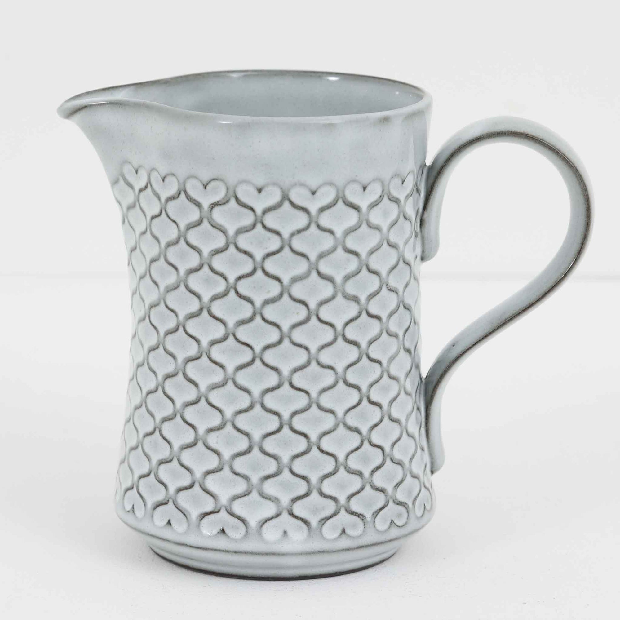 デンマークを代表するデザイナー、イェンス・H・クイストゴーによる「Cordial（コーディアル）」シリーズのヴィンテージ・ミルクジャグ（ピッチャー）です。1960年代にKronjydenから制作が始まったシリーズは、その後Nissen、Bing&Grondahlと引き継がれ長く愛されたシリーズとなりました。淡いグレーのストーンウェアにハートを連想させる繊細な型押し模様が施されており、デンマークではスウェーデンやフィンランドの陶器メーカーと並んで今でも非常に人気のある商品となります。