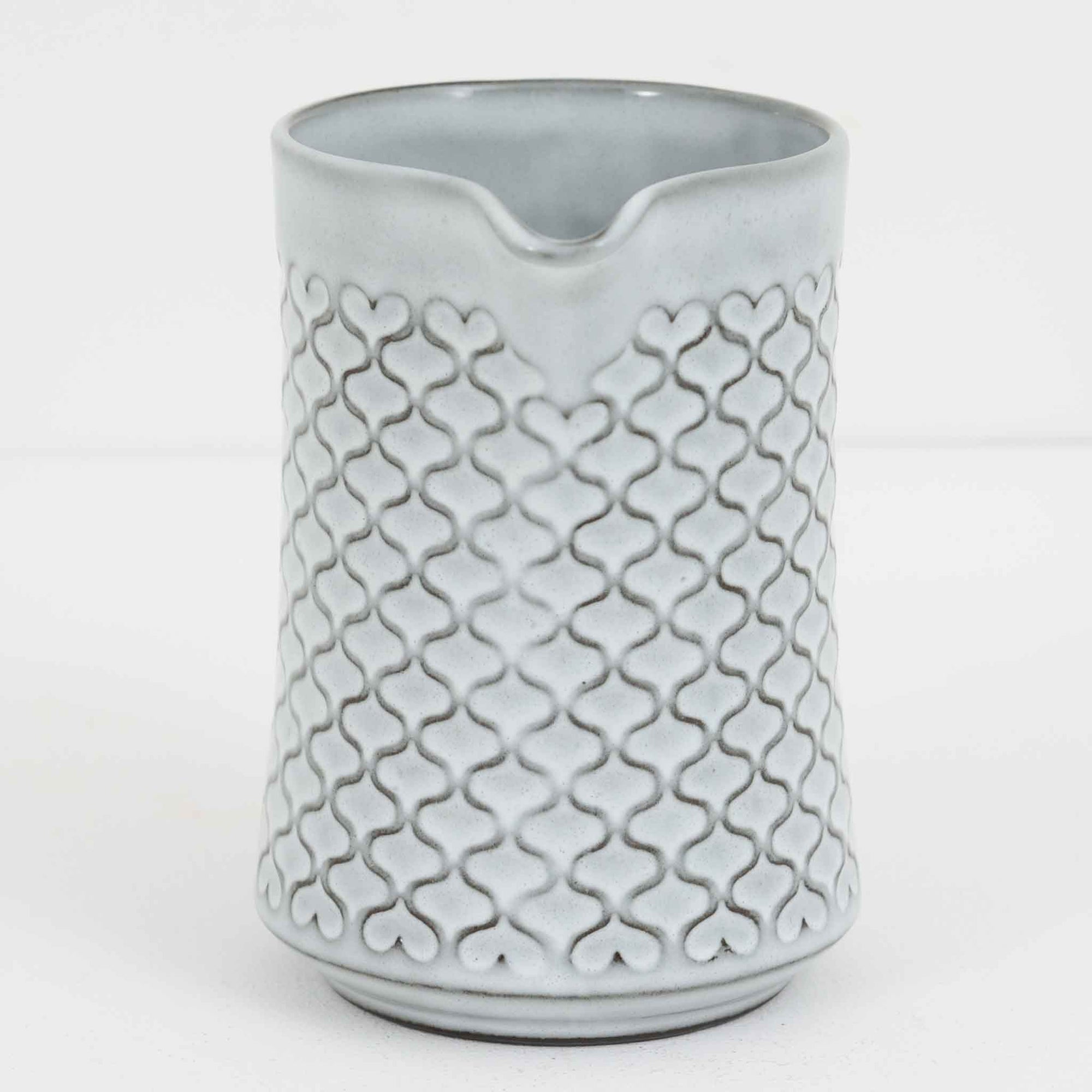 デンマークを代表するデザイナー、イェンス・H・クイストゴーによる「Cordial（コーディアル）」シリーズのヴィンテージ・ミルクジャグ（ピッチャー）です。1960年代にKronjydenから制作が始まったシリーズは、その後Nissen、Bing&Grondahlと引き継がれ長く愛されたシリーズとなりました。淡いグレーのストーンウェアにハートを連想させる繊細な型押し模様が施されており、デンマークではスウェーデンやフィンランドの陶器メーカーと並んで今でも非常に人気のある商品となります。