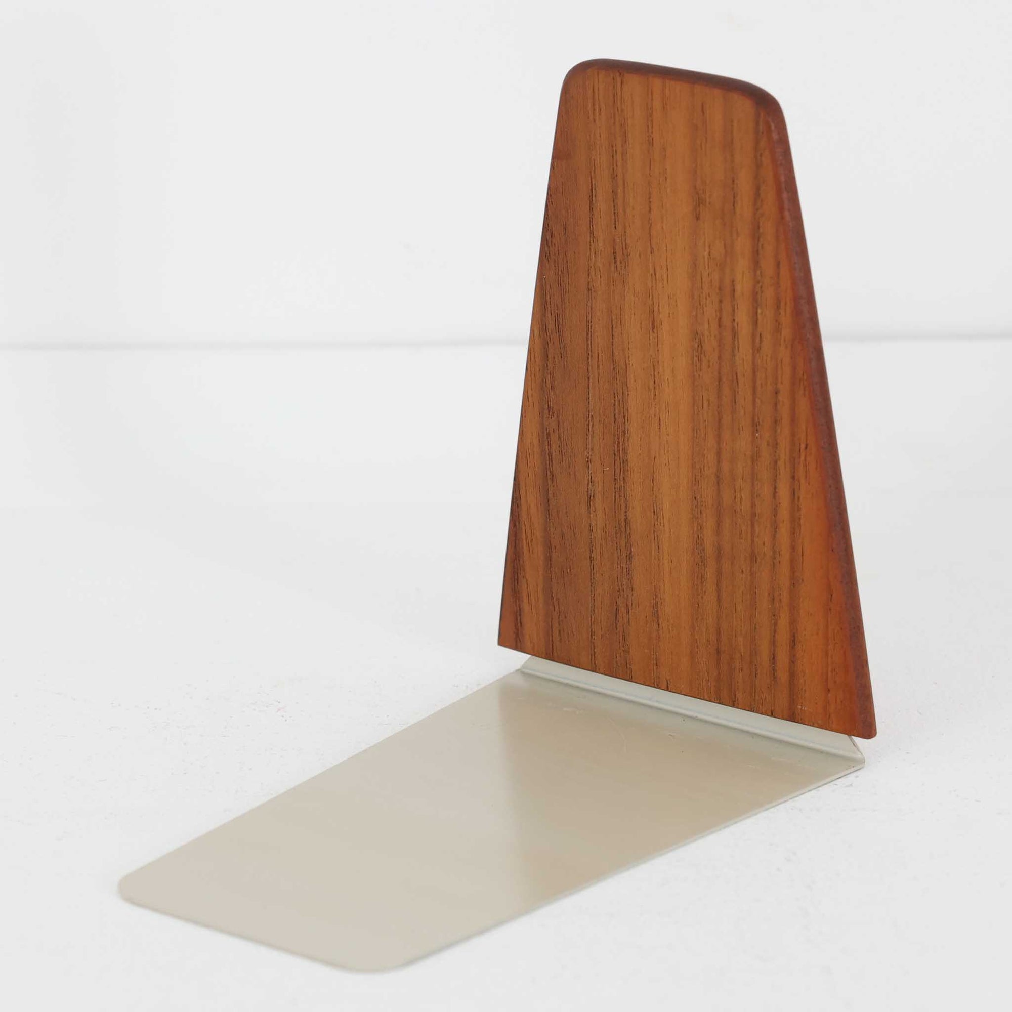 北欧デザインの温もりを感じさせる、デンマーク製ヴィンテージのブックエンドです。1960〜80年代頃に製造されたとみられ、素材には希少なチーク材を使用。深みのある色合いと美しい木目は、経年によってさらに味わいを増し、空間に落ち着きと上質さをもたらします。シンプルでありながら洗練されたフォルムは、北欧モダンらしいミニマルな美しさを体現しており、実用性とインテリア性を兼ね備え、書棚やデスクまわりを上品に演出します。