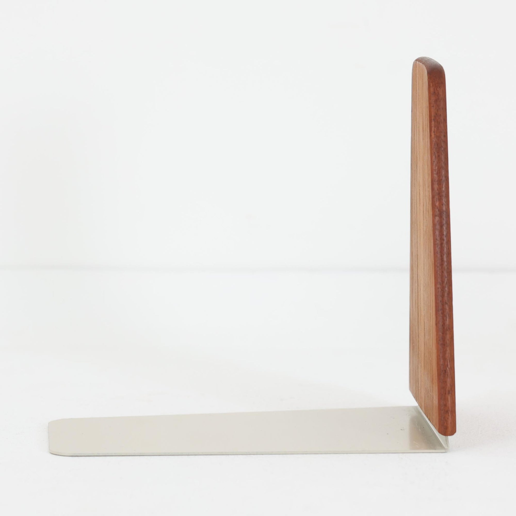 北欧デザインの温もりを感じさせる、デンマーク製ヴィンテージのブックエンドです。1960〜80年代頃に製造されたとみられ、素材には希少なチーク材を使用。深みのある色合いと美しい木目は、経年によってさらに味わいを増し、空間に落ち着きと上質さをもたらします。シンプルでありながら洗練されたフォルムは、北欧モダンらしいミニマルな美しさを体現しており、実用性とインテリア性を兼ね備え、書棚やデスクまわりを上品に演出します。