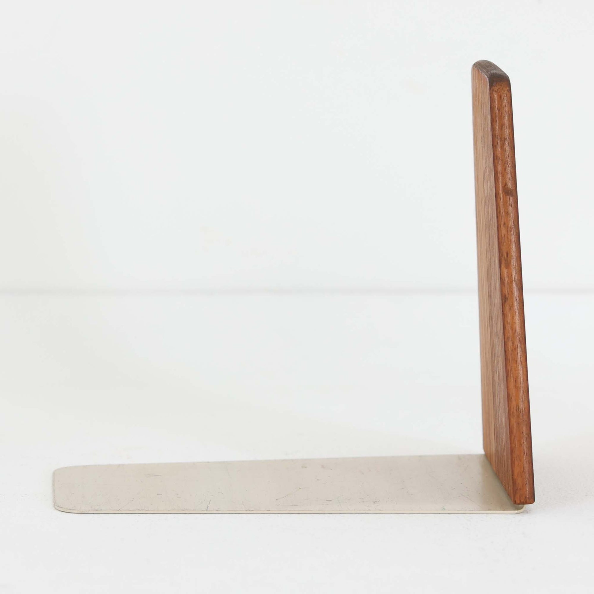 北欧デザインの温もりを感じさせる、デンマーク製ヴィンテージのブックエンドです。1960〜80年代頃に製造されたとみられ、素材には希少なチーク材を使用。深みのある色合いと美しい木目は、経年によってさらに味わいを増し、空間に落ち着きと上質さをもたらします。シンプルでありながら洗練されたフォルムは、北欧モダンらしいミニマルな美しさを体現しており、実用性とインテリア性を兼ね備え、書棚やデスクまわりを上品に演出します。