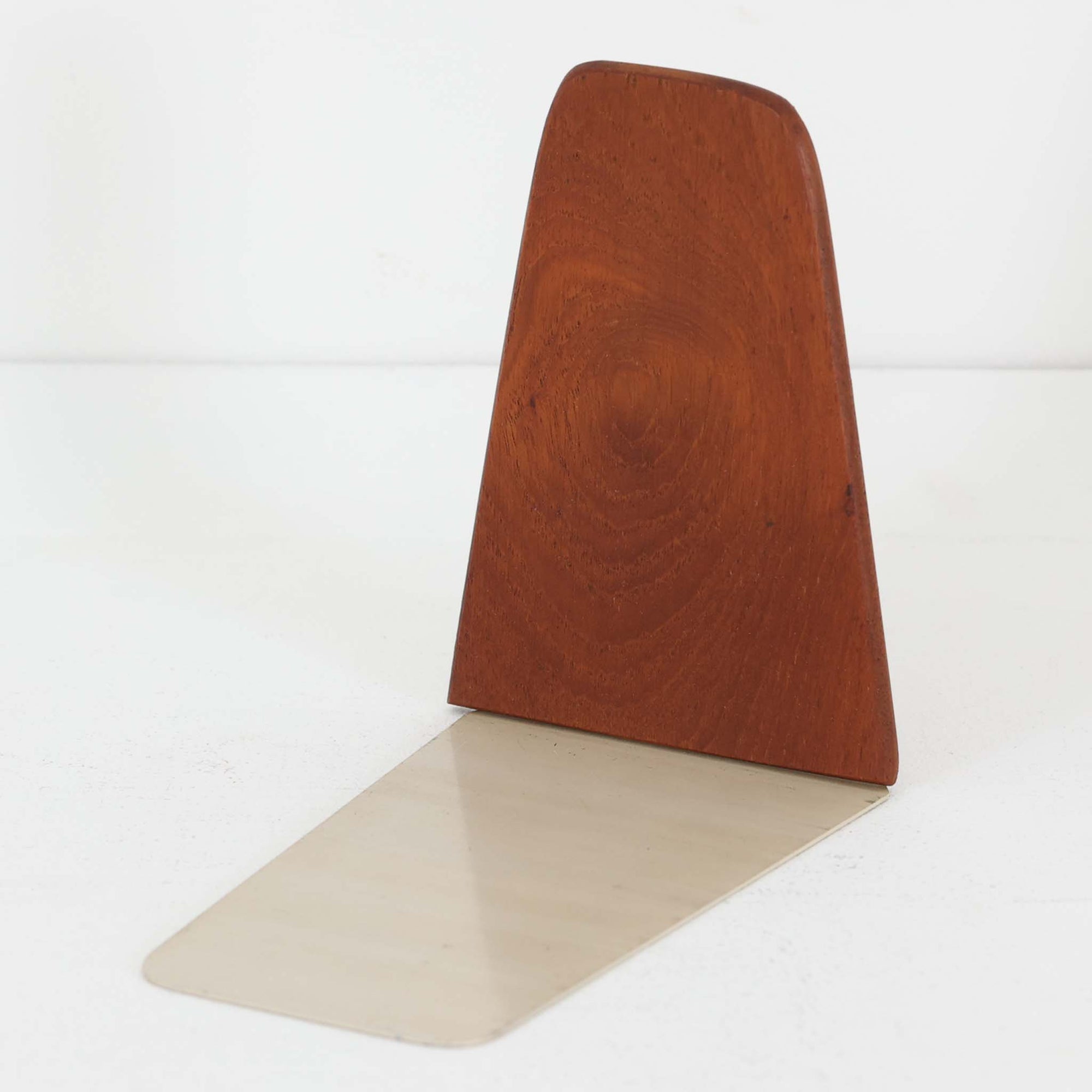 北欧デザインの温もりを感じさせる、デンマーク製ヴィンテージのブックエンドです。1960〜80年代頃に製造されたとみられ、素材には希少なチーク材を使用。深みのある色合いと美しい木目は、経年によってさらに味わいを増し、空間に落ち着きと上質さをもたらします。シンプルでありながら洗練されたフォルムは、北欧モダンらしいミニマルな美しさを体現しており、実用性とインテリア性を兼ね備え、書棚やデスクまわりを上品に演出します。