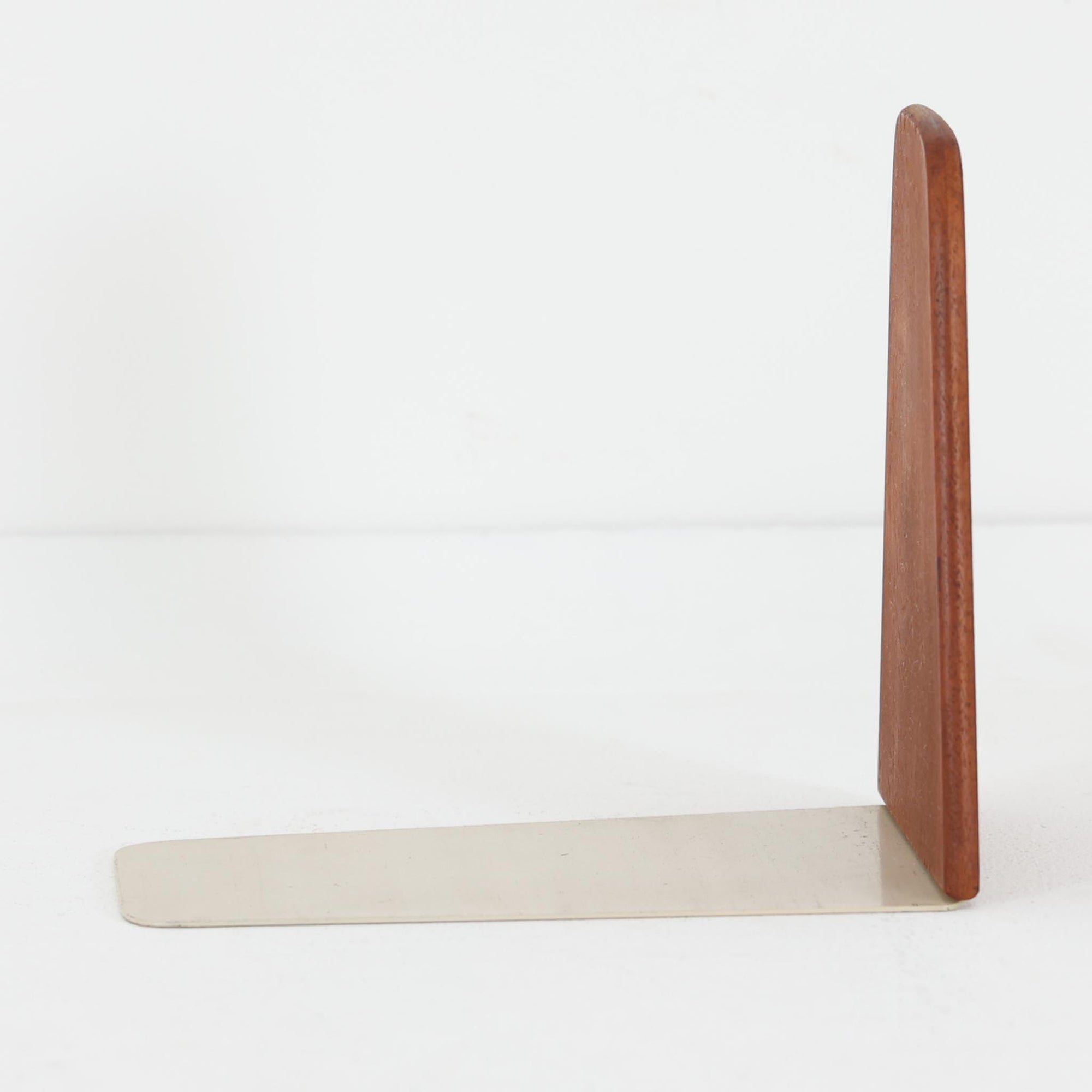 北欧デザインの温もりを感じさせる、デンマーク製ヴィンテージのブックエンドです。1960〜80年代頃に製造されたとみられ、素材には希少なチーク材を使用。深みのある色合いと美しい木目は、経年によってさらに味わいを増し、空間に落ち着きと上質さをもたらします。シンプルでありながら洗練されたフォルムは、北欧モダンらしいミニマルな美しさを体現しており、実用性とインテリア性を兼ね備え、書棚やデスクまわりを上品に演出します。