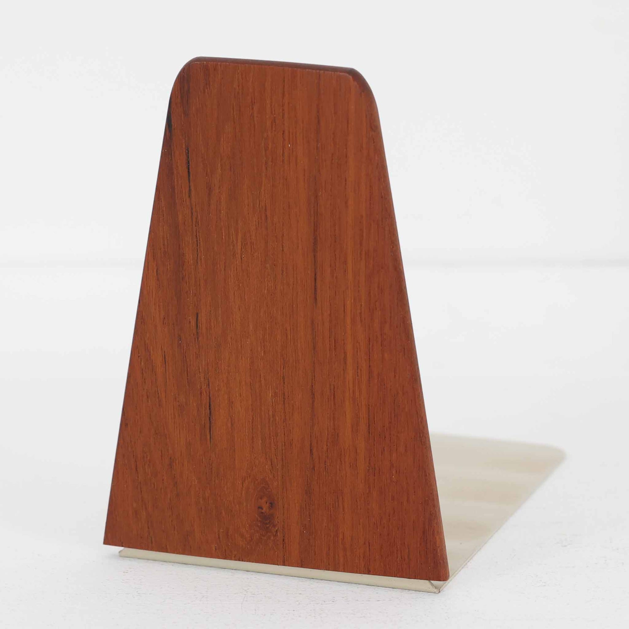 北欧デザインの温もりを感じさせる、デンマーク製ヴィンテージのブックエンドです。1960〜80年代頃に製造されたとみられ、素材には希少なチーク材を使用。深みのある色合いと美しい木目は、経年によってさらに味わいを増し、空間に落ち着きと上質さをもたらします。シンプルでありながら洗練されたフォルムは、北欧モダンらしいミニマルな美しさを体現しており、実用性とインテリア性を兼ね備え、書棚やデスクまわりを上品に演出します。