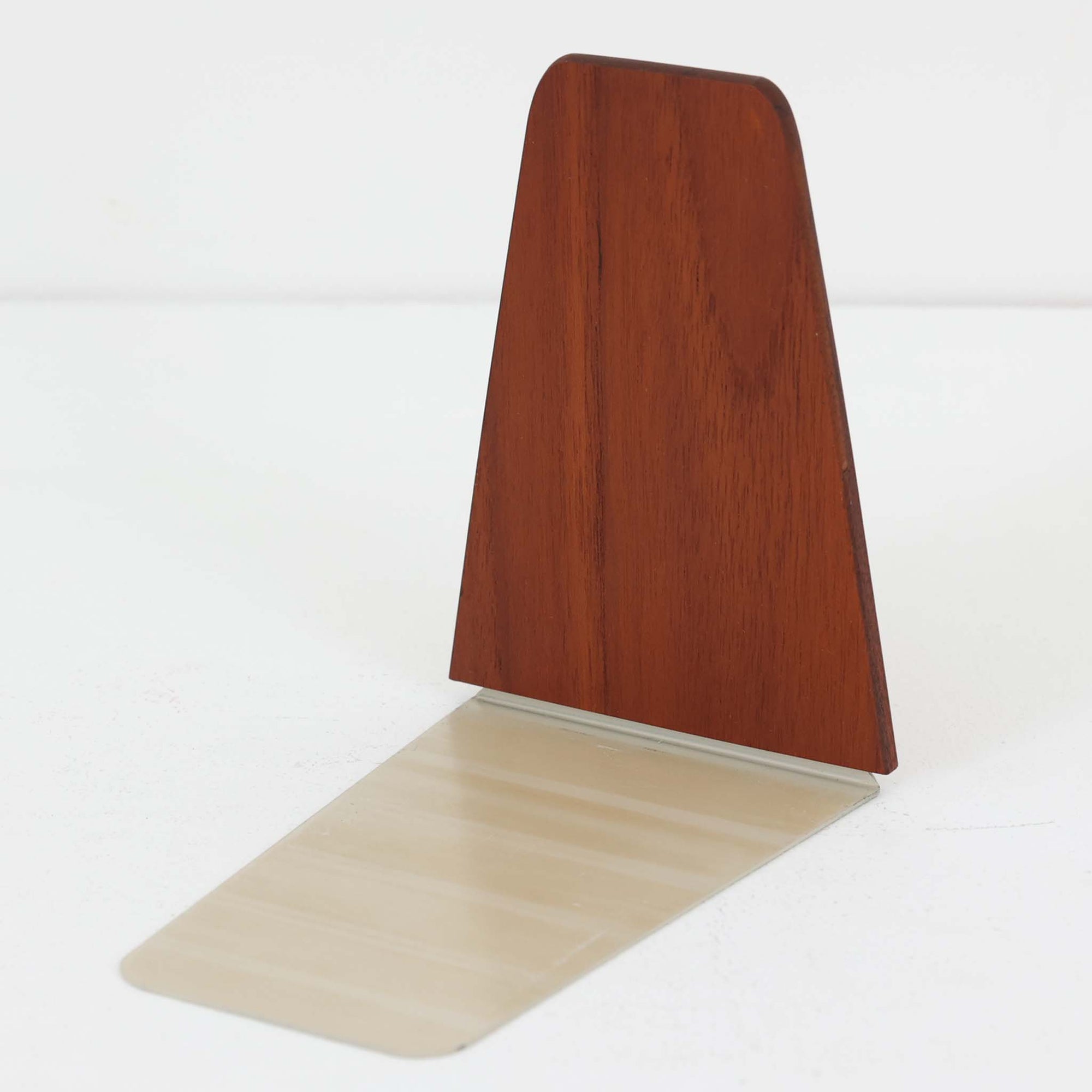 北欧デザインの温もりを感じさせる、デンマーク製ヴィンテージのブックエンドです。1960〜80年代頃に製造されたとみられ、素材には希少なチーク材を使用。深みのある色合いと美しい木目は、経年によってさらに味わいを増し、空間に落ち着きと上質さをもたらします。シンプルでありながら洗練されたフォルムは、北欧モダンらしいミニマルな美しさを体現しており、実用性とインテリア性を兼ね備え、書棚やデスクまわりを上品に演出します。