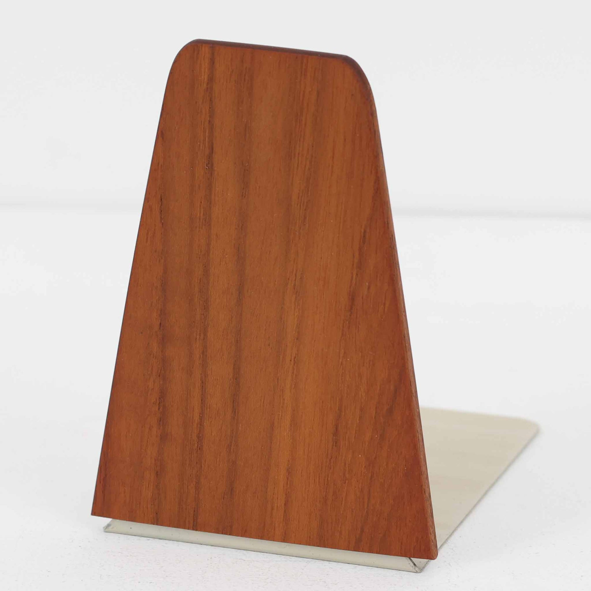 北欧デザインの温もりを感じさせる、デンマーク製ヴィンテージのブックエンドです。1960〜80年代頃に製造されたとみられ、素材には希少なチーク材を使用。深みのある色合いと美しい木目は、経年によってさらに味わいを増し、空間に落ち着きと上質さをもたらします。シンプルでありながら洗練されたフォルムは、北欧モダンらしいミニマルな美しさを体現しており、実用性とインテリア性を兼ね備え、書棚やデスクまわりを上品に演出します。