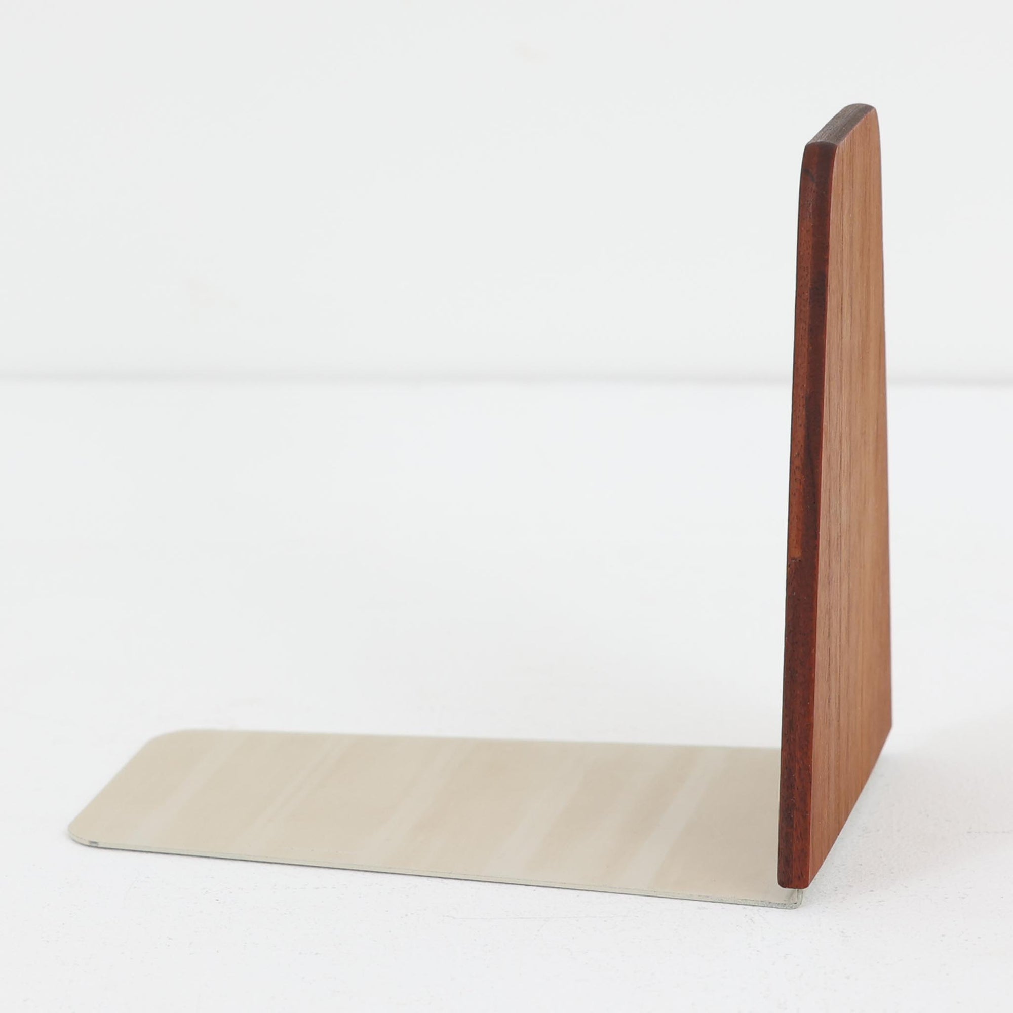 北欧デザインの温もりを感じさせる、デンマーク製ヴィンテージのブックエンドです。1960〜80年代頃に製造されたとみられ、素材には希少なチーク材を使用。深みのある色合いと美しい木目は、経年によってさらに味わいを増し、空間に落ち着きと上質さをもたらします。シンプルでありながら洗練されたフォルムは、北欧モダンらしいミニマルな美しさを体現しており、実用性とインテリア性を兼ね備え、書棚やデスクまわりを上品に演出します。