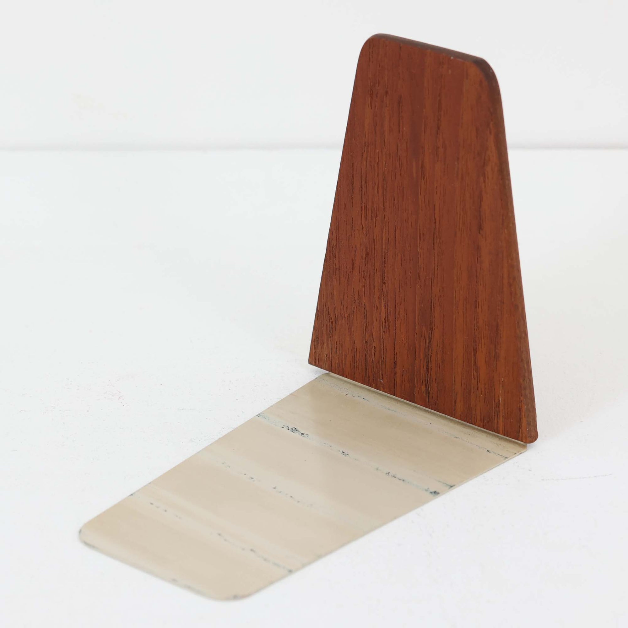 北欧デザインの温もりを感じさせる、デンマーク製ヴィンテージのブックエンドです。1960〜80年代頃に製造されたとみられ、素材には希少なチーク材を使用。深みのある色合いと美しい木目は、経年によってさらに味わいを増し、空間に落ち着きと上質さをもたらします。シンプルでありながら洗練されたフォルムは、北欧モダンらしいミニマルな美しさを体現しており、実用性とインテリア性を兼ね備え、書棚やデスクまわりを上品に演出します。