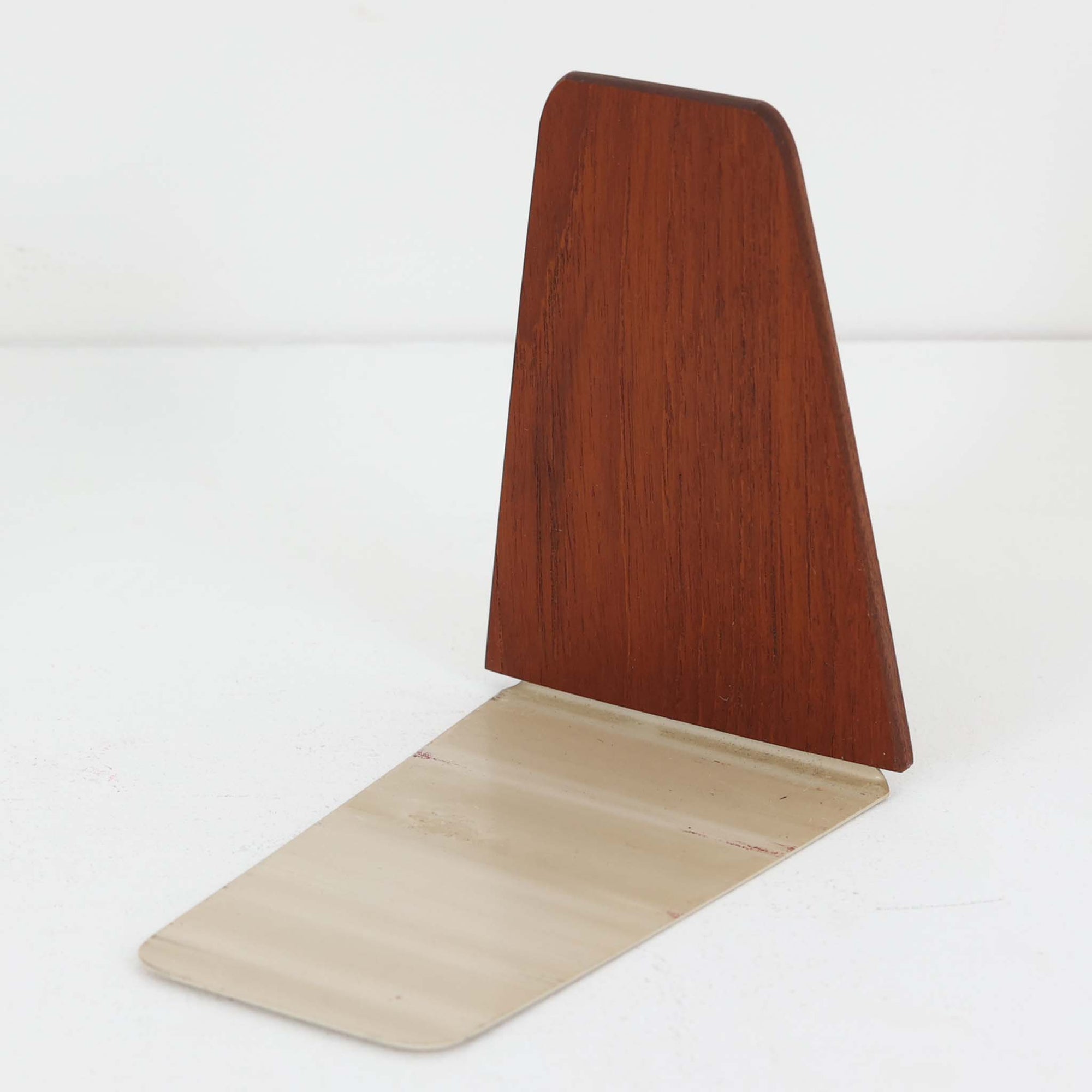 北欧デザインの温もりを感じさせる、デンマーク製ヴィンテージのブックエンドです。1960〜80年代頃に製造されたとみられ、素材には希少なチーク材を使用。深みのある色合いと美しい木目は、経年によってさらに味わいを増し、空間に落ち着きと上質さをもたらします。シンプルでありながら洗練されたフォルムは、北欧モダンらしいミニマルな美しさを体現しており、実用性とインテリア性を兼ね備え、書棚やデスクまわりを上品に演出します。