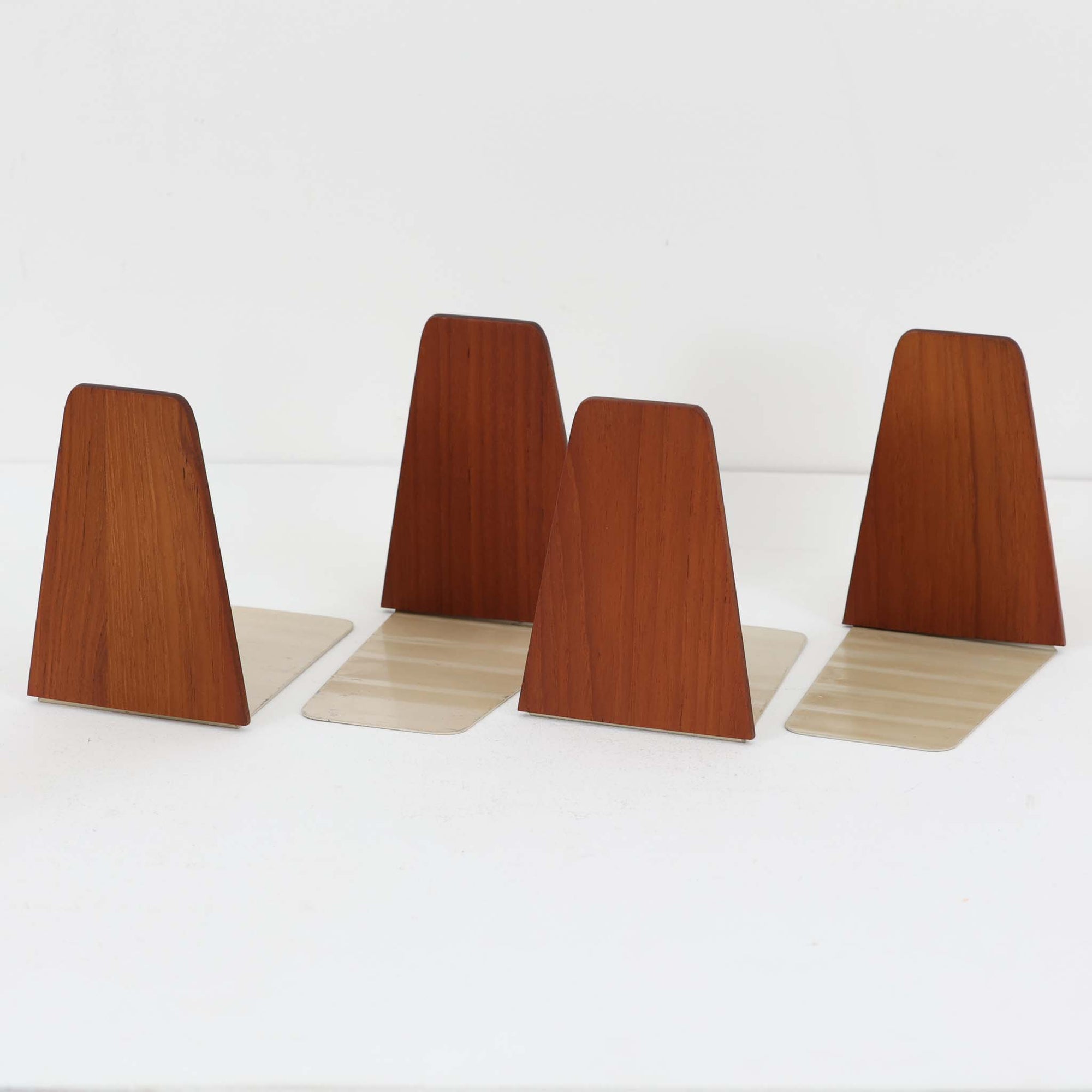 北欧デザインの温もりを感じさせる、デンマーク製ヴィンテージのブックエンドです。1960〜80年代頃に製造されたとみられ、素材には希少なチーク材を使用。深みのある色合いと美しい木目は、経年によってさらに味わいを増し、空間に落ち着きと上質さをもたらします。シンプルでありながら洗練されたフォルムは、北欧モダンらしいミニマルな美しさを体現しており、実用性とインテリア性を兼ね備え、書棚やデスクまわりを上品に演出します。