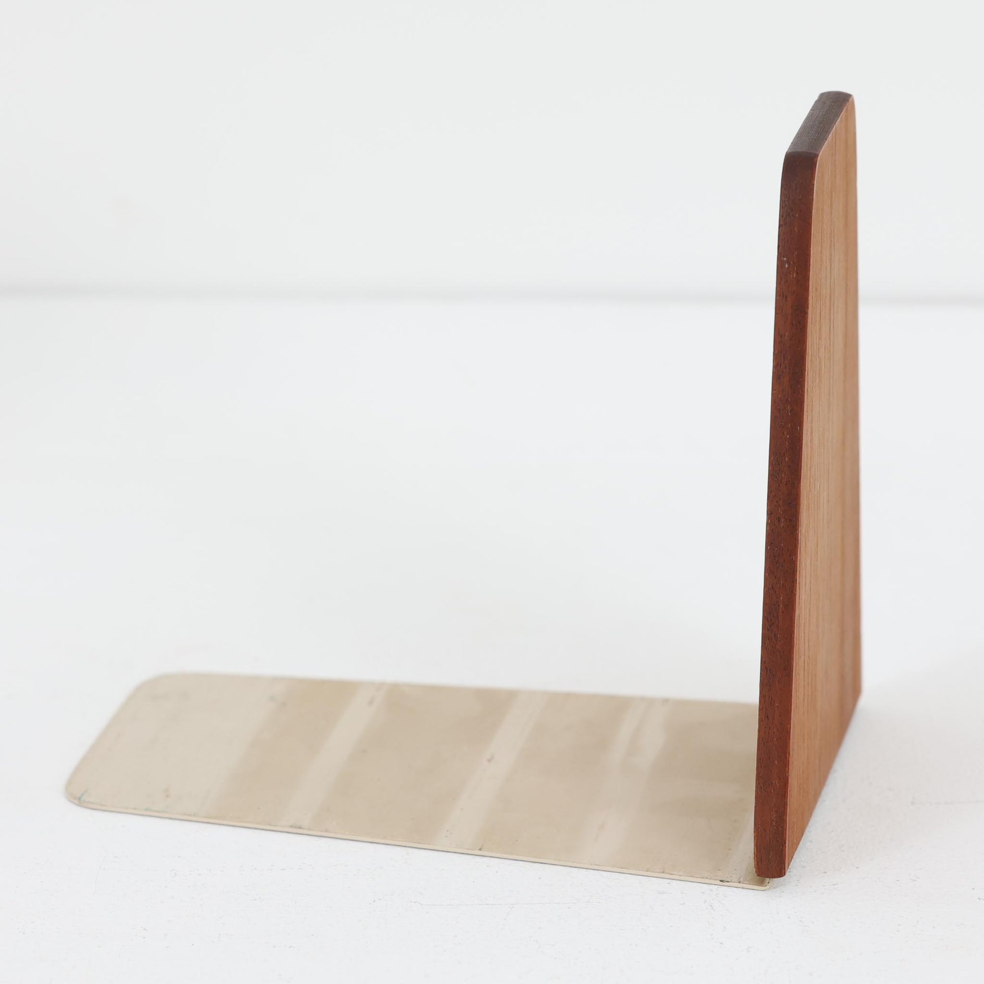 北欧デザインの温もりを感じさせる、デンマーク製ヴィンテージのブックエンドです。1960〜80年代頃に製造されたとみられ、素材には希少なチーク材を使用。深みのある色合いと美しい木目は、経年によってさらに味わいを増し、空間に落ち着きと上質さをもたらします。シンプルでありながら洗練されたフォルムは、北欧モダンらしいミニマルな美しさを体現しており、実用性とインテリア性を兼ね備え、書棚やデスクまわりを上品に演出します。