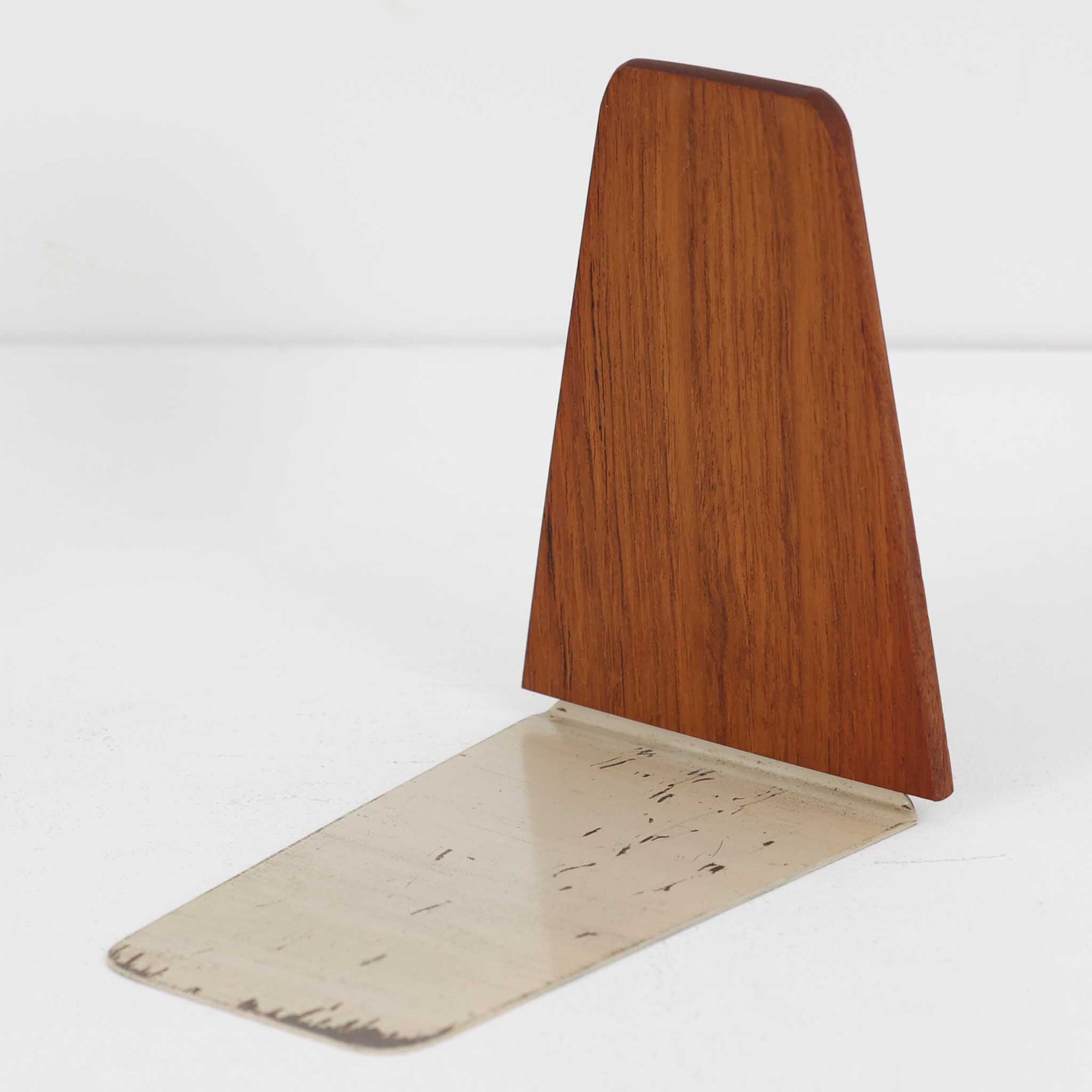 北欧デザインの温もりを感じさせる、デンマーク製ヴィンテージのブックエンドです。1960〜80年代頃に製造されたとみられ、素材には希少なチーク材を使用。深みのある色合いと美しい木目は、経年によってさらに味わいを増し、空間に落ち着きと上質さをもたらします。シンプルでありながら洗練されたフォルムは、北欧モダンらしいミニマルな美しさを体現しており、実用性とインテリア性を兼ね備え、書棚やデスクまわりを上品に演出します。