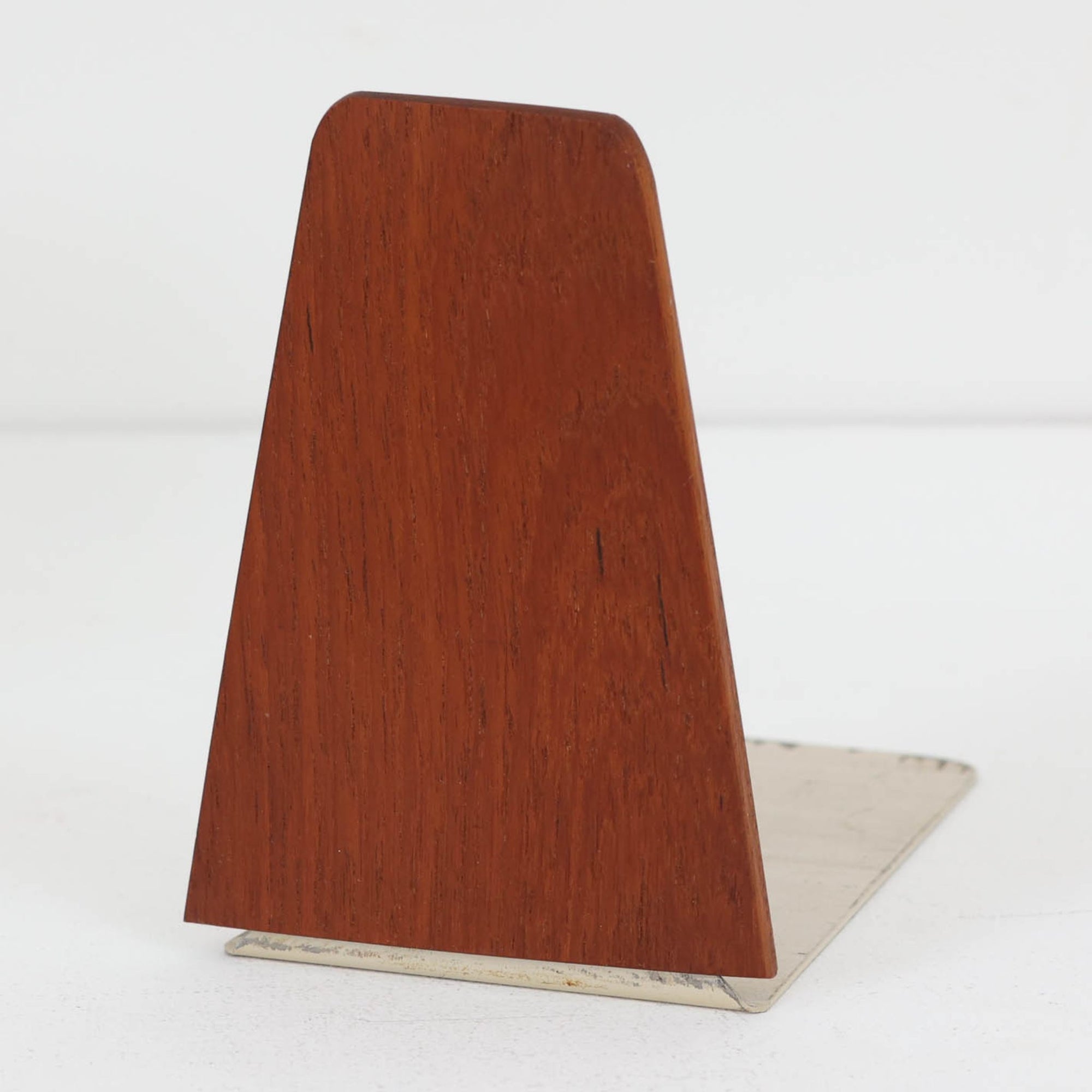 北欧デザインの温もりを感じさせる、デンマーク製ヴィンテージのブックエンドです。1960〜80年代頃に製造されたとみられ、素材には希少なチーク材を使用。深みのある色合いと美しい木目は、経年によってさらに味わいを増し、空間に落ち着きと上質さをもたらします。シンプルでありながら洗練されたフォルムは、北欧モダンらしいミニマルな美しさを体現しており、実用性とインテリア性を兼ね備え、書棚やデスクまわりを上品に演出します。