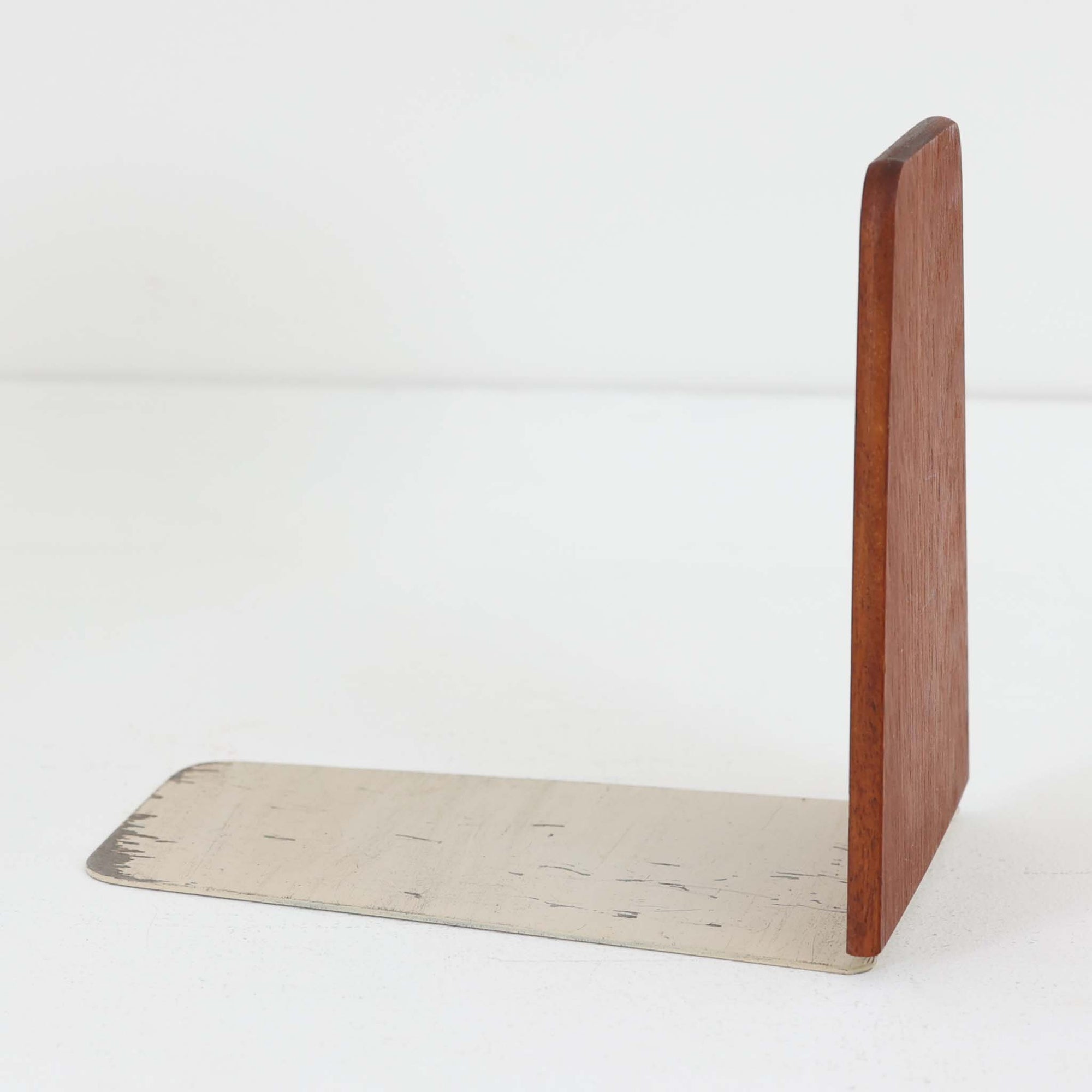 北欧デザインの温もりを感じさせる、デンマーク製ヴィンテージのブックエンドです。1960〜80年代頃に製造されたとみられ、素材には希少なチーク材を使用。深みのある色合いと美しい木目は、経年によってさらに味わいを増し、空間に落ち着きと上質さをもたらします。シンプルでありながら洗練されたフォルムは、北欧モダンらしいミニマルな美しさを体現しており、実用性とインテリア性を兼ね備え、書棚やデスクまわりを上品に演出します。