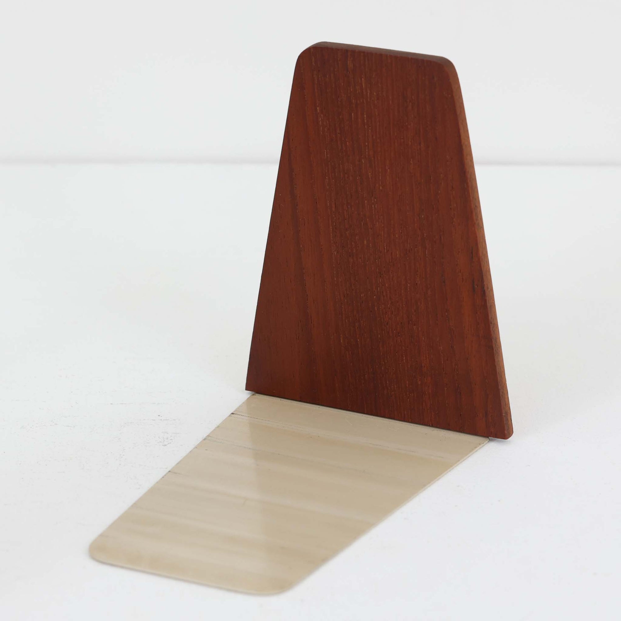 北欧デザインの温もりを感じさせる、デンマーク製ヴィンテージのブックエンドです。1960〜80年代頃に製造されたとみられ、素材には希少なチーク材を使用。深みのある色合いと美しい木目は、経年によってさらに味わいを増し、空間に落ち着きと上質さをもたらします。シンプルでありながら洗練されたフォルムは、北欧モダンらしいミニマルな美しさを体現しており、実用性とインテリア性を兼ね備え、書棚やデスクまわりを上品に演出します。