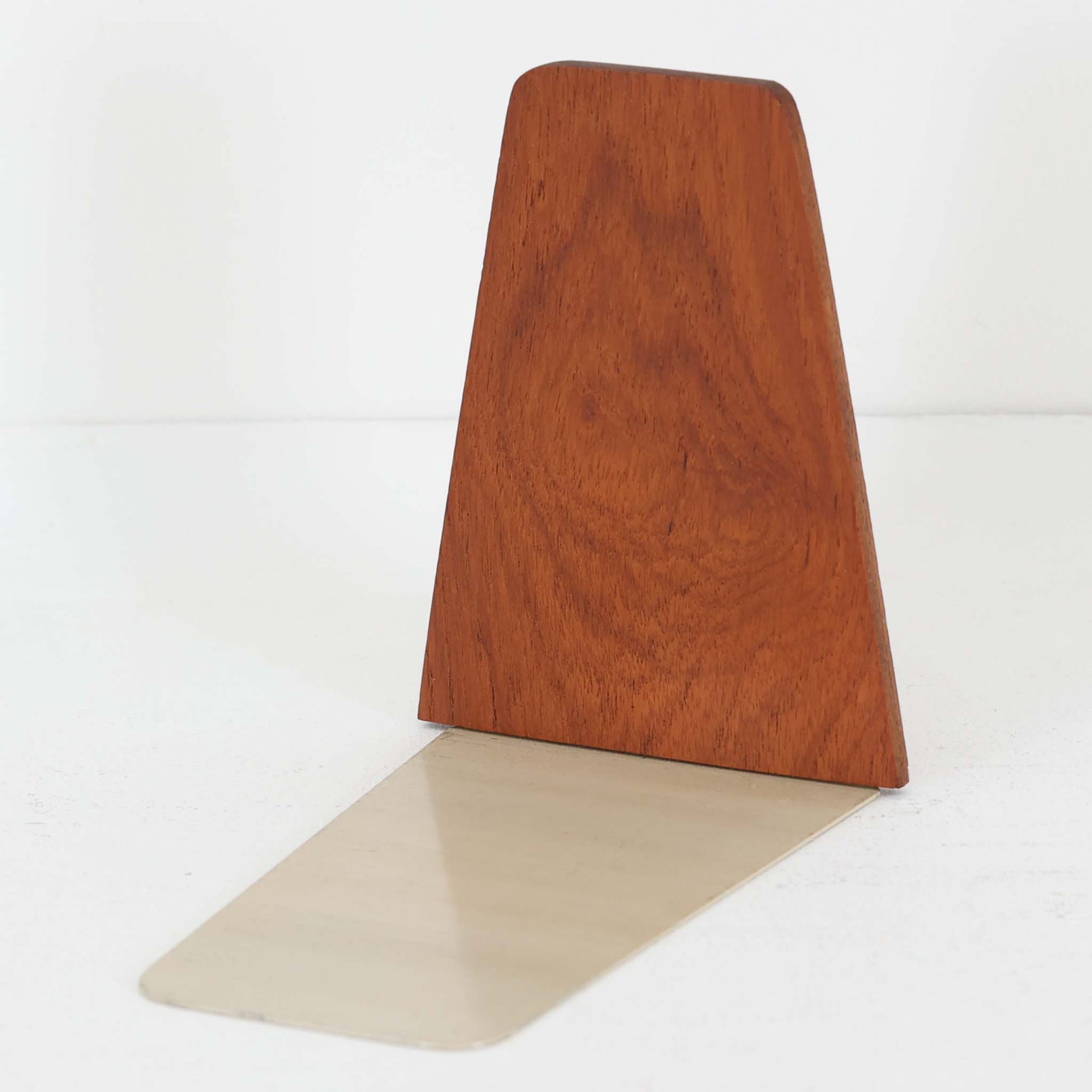 北欧デザインの温もりを感じさせる、デンマーク製ヴィンテージのブックエンドです。1960〜80年代頃に製造されたとみられ、素材には希少なチーク材を使用。深みのある色合いと美しい木目は、経年によってさらに味わいを増し、空間に落ち着きと上質さをもたらします。シンプルでありながら洗練されたフォルムは、北欧モダンらしいミニマルな美しさを体現しており、実用性とインテリア性を兼ね備え、書棚やデスクまわりを上品に演出します。