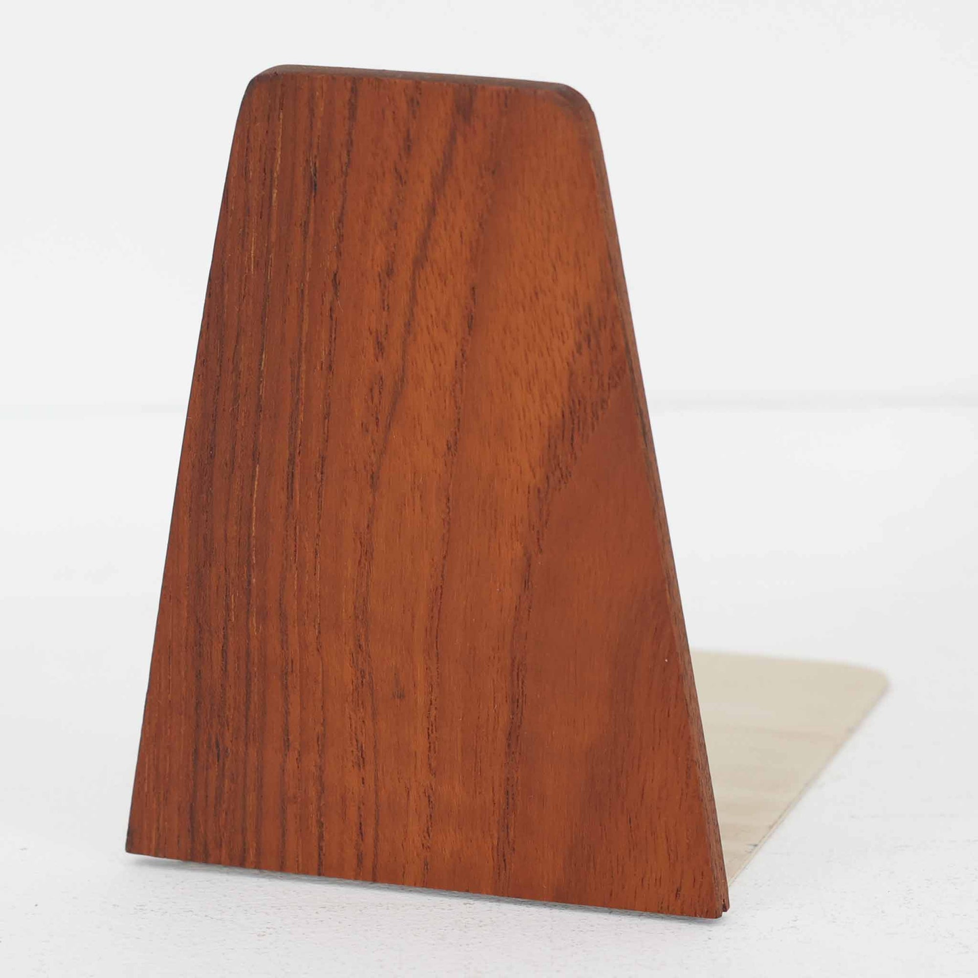 北欧デザインの温もりを感じさせる、デンマーク製ヴィンテージのブックエンドです。1960〜80年代頃に製造されたとみられ、素材には希少なチーク材を使用。深みのある色合いと美しい木目は、経年によってさらに味わいを増し、空間に落ち着きと上質さをもたらします。シンプルでありながら洗練されたフォルムは、北欧モダンらしいミニマルな美しさを体現しており、実用性とインテリア性を兼ね備え、書棚やデスクまわりを上品に演出します。
