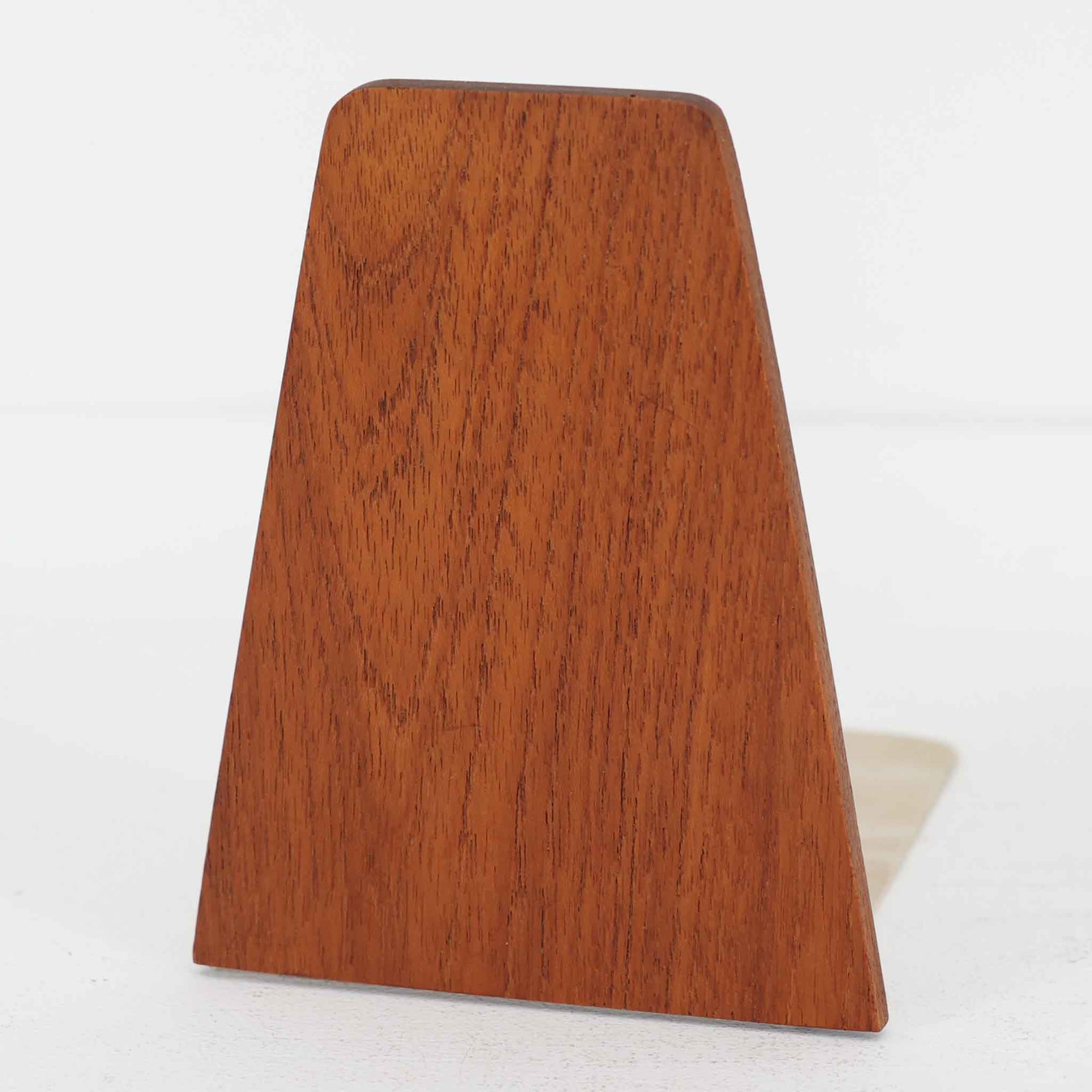 北欧デザインの温もりを感じさせる、デンマーク製ヴィンテージのブックエンドです。1960〜80年代頃に製造されたとみられ、素材には希少なチーク材を使用。深みのある色合いと美しい木目は、経年によってさらに味わいを増し、空間に落ち着きと上質さをもたらします。シンプルでありながら洗練されたフォルムは、北欧モダンらしいミニマルな美しさを体現しており、実用性とインテリア性を兼ね備え、書棚やデスクまわりを上品に演出します。