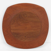 1960年代、デンマーク・モダンの黄金期にポール・クヌーセンが手がけたチーク無垢材のプレートです。「実用工芸」を意味するブランド名の通り、木の質感を活かした滑らかな曲線と、洗練されたミニマルな造形美が魅力。半世紀を経て深く色づいたチーク材は「木の宝石」と称されるほど美しく、食卓に温かな品格を添えます。食器としてはもちろん、インテリアトレイとしても重宝する、一期一会のヴィンテージ名作です。