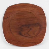 1960年代、デンマーク・モダンの黄金期にポール・クヌーセンが手がけたチーク無垢材のプレートです。「実用工芸」を意味するブランド名の通り、木の質感を活かした滑らかな曲線と、洗練されたミニマルな造形美が魅力。半世紀を経て深く色づいたチーク材は「木の宝石」と称されるほど美しく、食卓に温かな品格を添えます。食器としてはもちろん、インテリアトレイとしても重宝する、一期一会のヴィンテージ名作です。