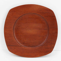 1960年代、デンマーク・モダンの黄金期にポール・クヌーセンが手がけたチーク無垢材のプレートです。「実用工芸」を意味するブランド名の通り、木の質感を活かした滑らかな曲線と、洗練されたミニマルな造形美が魅力。半世紀を経て深く色づいたチーク材は「木の宝石」と称されるほど美しく、食卓に温かな品格を添えます。食器としてはもちろん、インテリアトレイとしても重宝する、一期一会のヴィンテージ名作です。