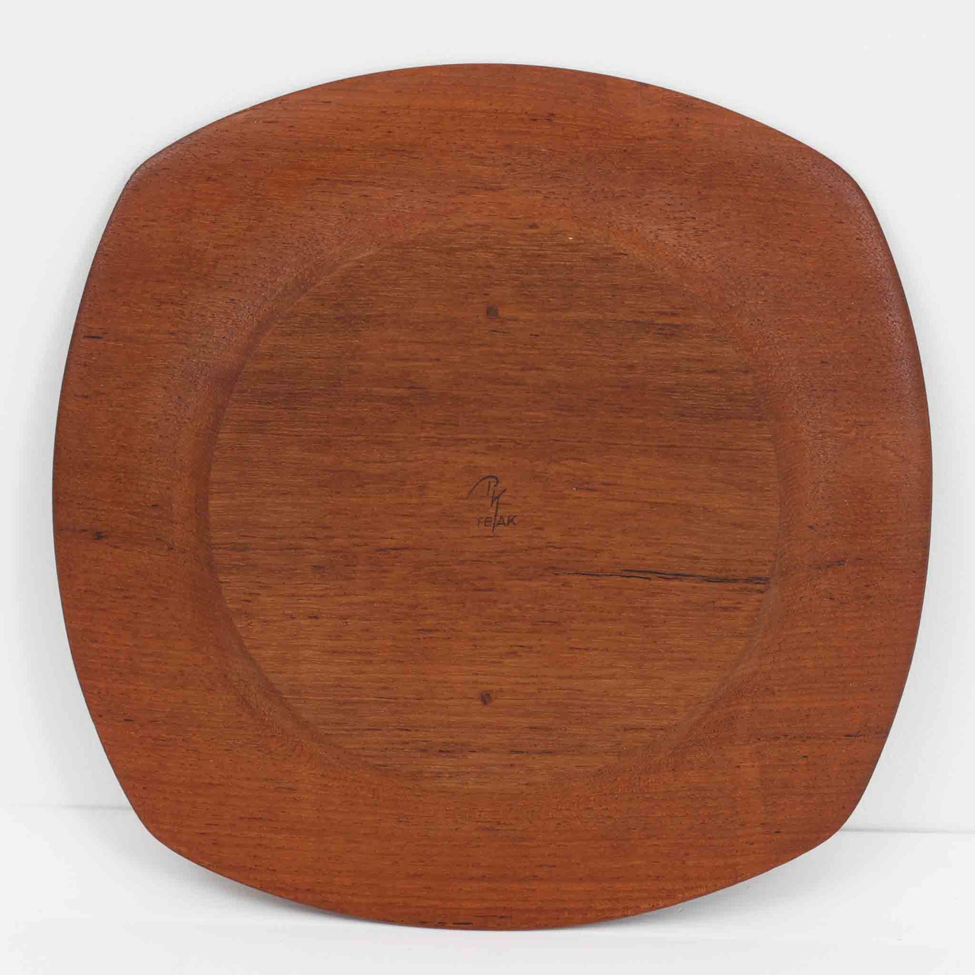 1960年代、デンマーク・モダンの黄金期にポール・クヌーセンが手がけたチーク無垢材のプレートです。「実用工芸」を意味するブランド名の通り、木の質感を活かした滑らかな曲線と、洗練されたミニマルな造形美が魅力。半世紀を経て深く色づいたチーク材は「木の宝石」と称されるほど美しく、食卓に温かな品格を添えます。食器としてはもちろん、インテリアトレイとしても重宝する、一期一会のヴィンテージ名作です。