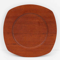 1960年代、デンマーク・モダンの黄金期にポール・クヌーセンが手がけたチーク無垢材のプレートです。「実用工芸」を意味するブランド名の通り、木の質感を活かした滑らかな曲線と、洗練されたミニマルな造形美が魅力。半世紀を経て深く色づいたチーク材は「木の宝石」と称されるほど美しく、食卓に温かな品格を添えます。食器としてはもちろん、インテリアトレイとしても重宝する、一期一会のヴィンテージ名作です。