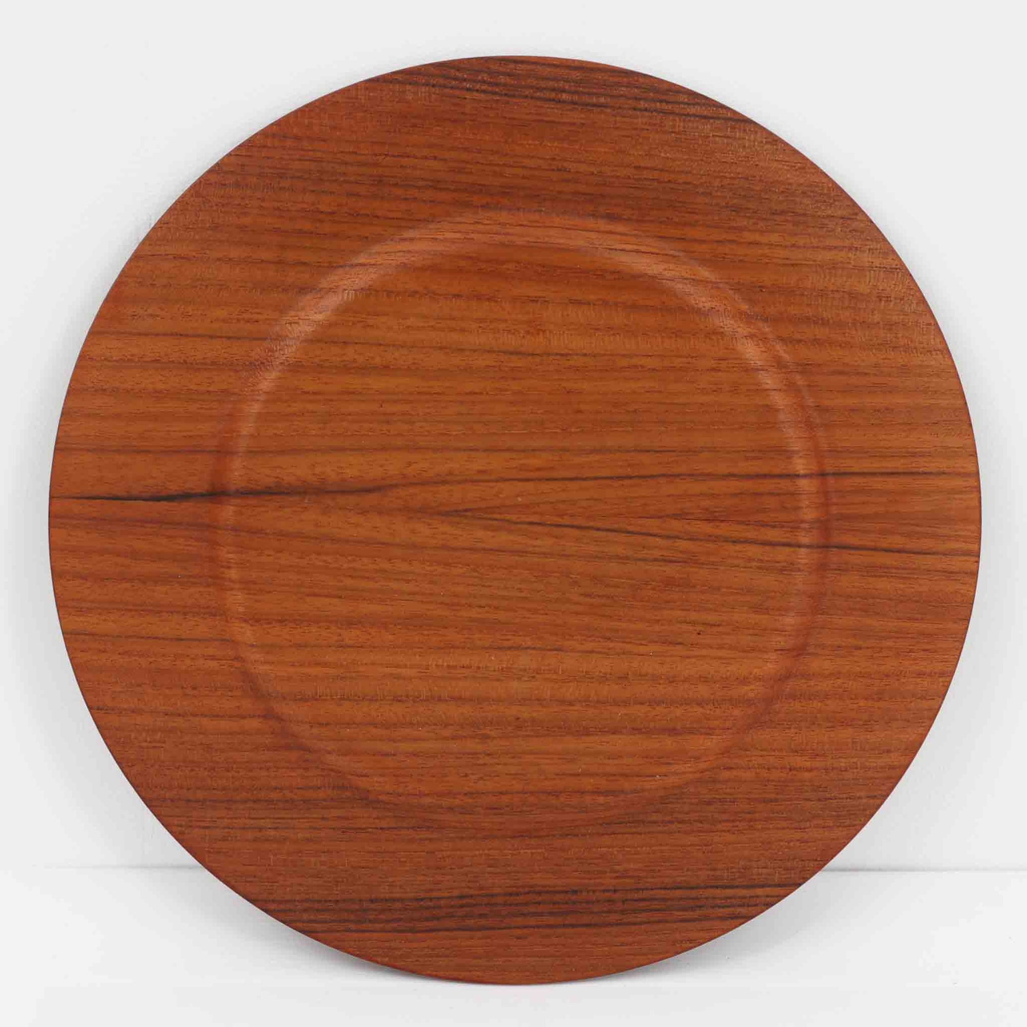 北欧ヴィンテージらしい、あたたかみのある木目が魅力のチーク材プレートです。突板（プライウッド）仕様のため、軽やかで扱いやすく、テーブルの雰囲気を上品にまとめてくれます。メーカー刻印等は見当たらず詳細は不明ですが、形状や素材感から1960年代頃のデンマーク製と思われます。アクセサリートレイや小物置きとしても使いやすい一枚です。