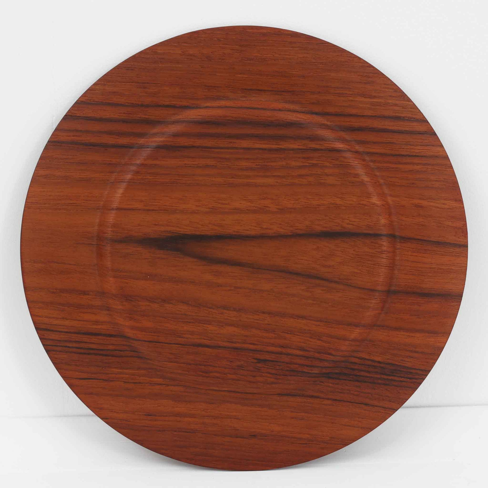 北欧ヴィンテージらしい、あたたかみのある木目が魅力のチーク材プレートです。突板（プライウッド）仕様のため、軽やかで扱いやすく、テーブルの雰囲気を上品にまとめてくれます。メーカー刻印等は見当たらず詳細は不明ですが、形状や素材感から1960年代頃のデンマーク製と思われます。アクセサリートレイや小物置きとしても使いやすい一枚です。