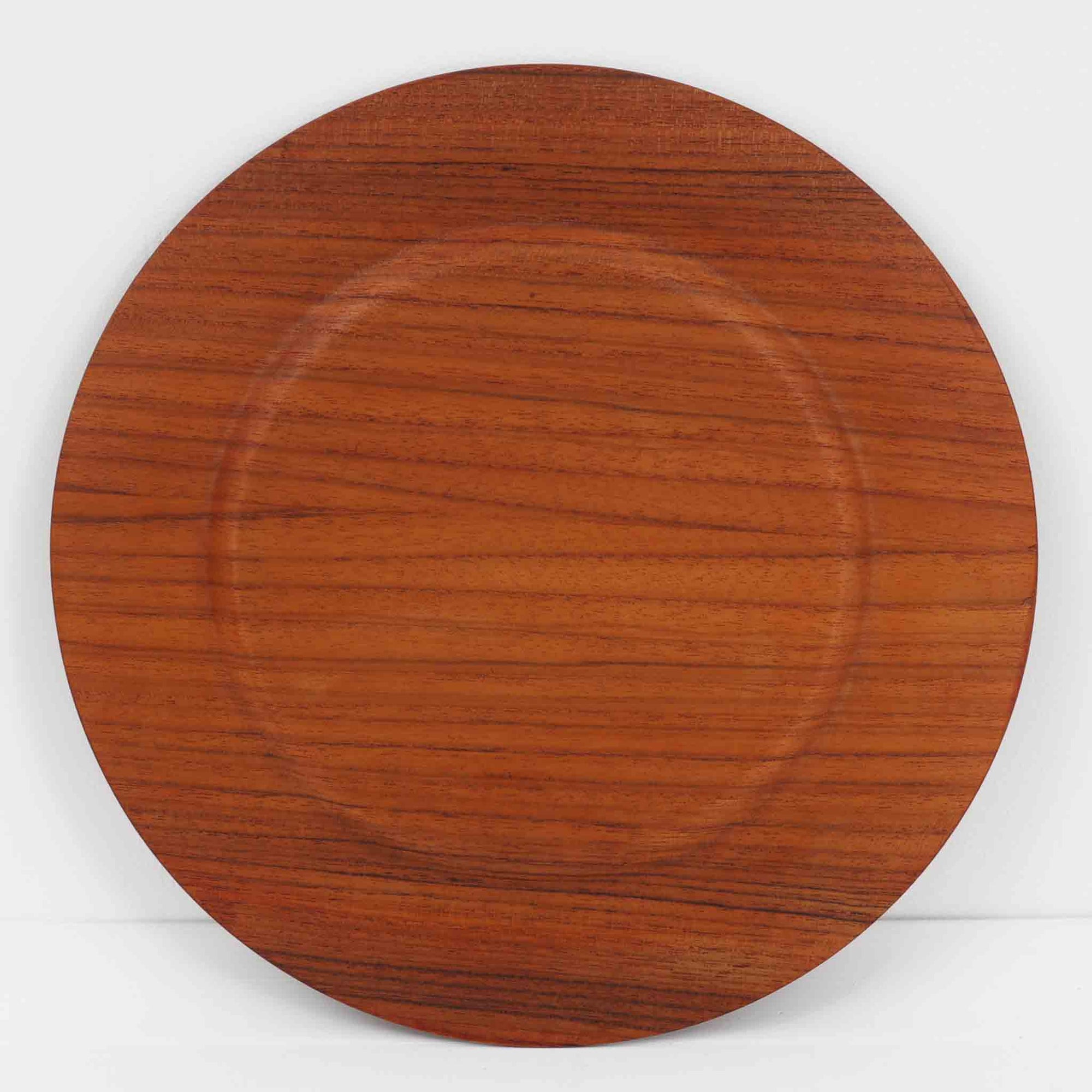 北欧ヴィンテージらしい、あたたかみのある木目が魅力のチーク材プレートです。突板（プライウッド）仕様のため、軽やかで扱いやすく、テーブルの雰囲気を上品にまとめてくれます。メーカー刻印等は見当たらず詳細は不明ですが、形状や素材感から1960年代頃のデンマーク製と思われます。アクセサリートレイや小物置きとしても使いやすい一枚です。