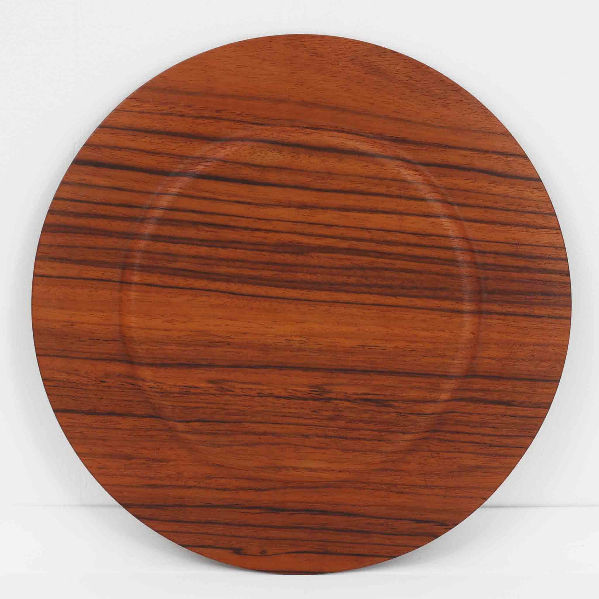 北欧ヴィンテージらしい、あたたかみのある木目が魅力のチーク材プレートです。突板（プライウッド）仕様のため、軽やかで扱いやすく、テーブルの雰囲気を上品にまとめてくれます。メーカー刻印等は見当たらず詳細は不明ですが、形状や素材感から1960年代頃のデンマーク製と思われます。アクセサリートレイや小物置きとしても使いやすい一枚です。