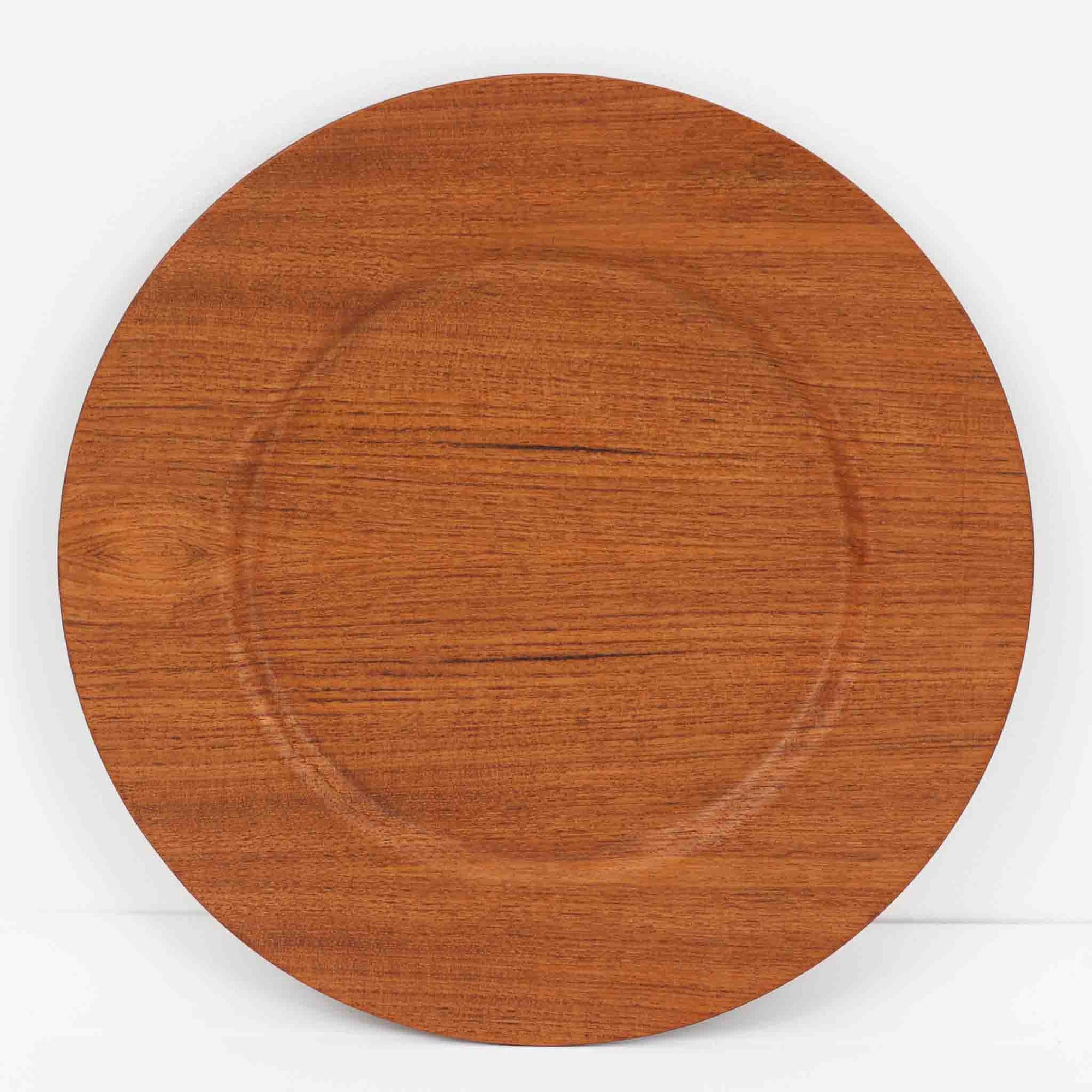 北欧ヴィンテージらしい、あたたかみのある木目が魅力のチーク材プレートです。突板（プライウッド）仕様のため、軽やかで扱いやすく、テーブルの雰囲気を上品にまとめてくれます。メーカー刻印等は見当たらず詳細は不明ですが、形状や素材感から1960年代頃のデンマーク製と思われます。アクセサリートレイや小物置きとしても使いやすい一枚です。