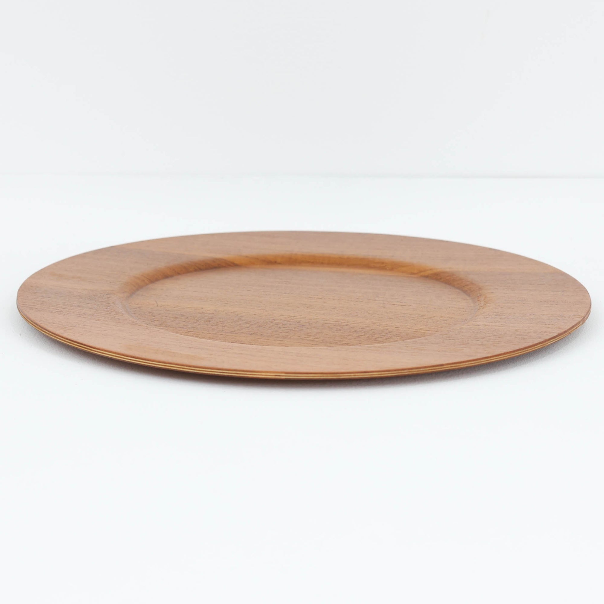 北欧ヴィンテージらしい、あたたかみのある木目が魅力のチーク材プレートです。突板（プライウッド）仕様のため、軽やかで扱いやすく、テーブルの雰囲気を上品にまとめてくれます。メーカー刻印等は見当たらず詳細は不明ですが、形状や素材感から1960年代頃のデンマーク製と思われます。アクセサリートレイや小物置きとしても使いやすい一枚です。