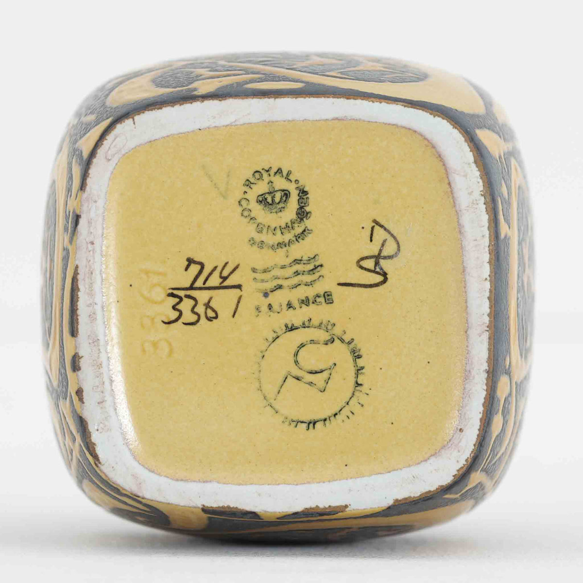 Royal Copenhagen（ロイヤルコペンハーゲン）のヴィンテージフラワーベースです。Nils Thorsson（ニルス・トーソン）が手掛けた、小ぶりながらも存在感のあるデザインが魅力の一品。ブラックに近い深い色調をベースに、マスタードイエローやグレーを組み合わせた装飾が施され、植物や花を思わせる抽象的なモチーフが器全体を彩ります。コンパクトで取り入れやすく、小さな草花を生ける花器としてはもちろん、そのままオブジェとして飾っても絵になるデザインです。重厚感のある色使いと力強い意匠にはNils Thorssonらしい芸術性が感じられ、北欧ヴィンテージ陶器やミッドセンチュリーデザインがお好きな方にもおすすめです。