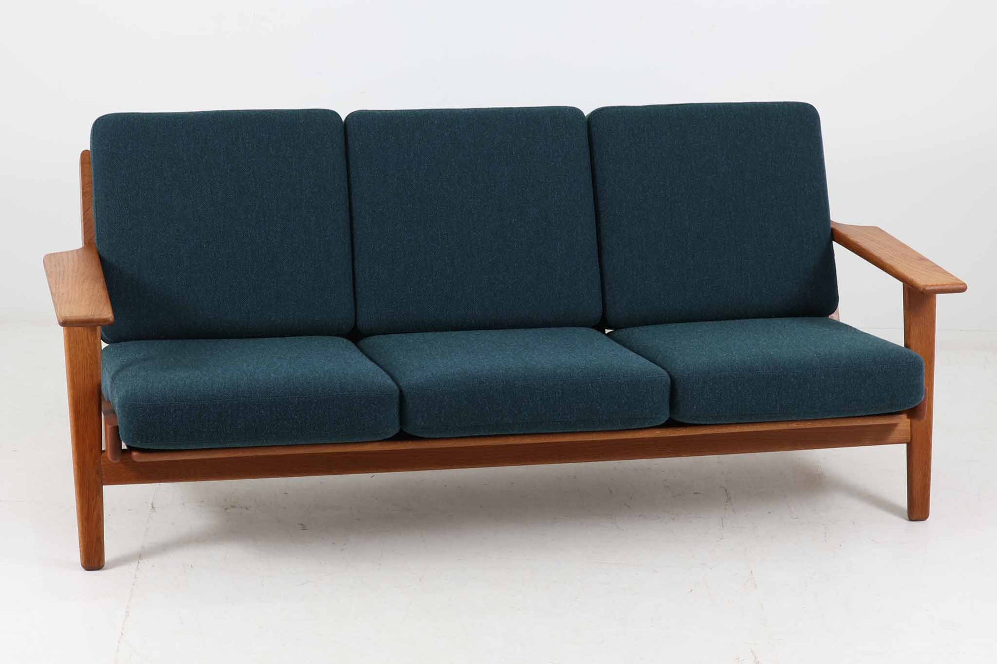 北欧家具を代表するソファ『GE290』です。現在リプロダクト品が販売されていますが、こちらは本物です。元々はベッド会社であるGETAmA社ならではのコイルスプリングが内包されたクッションの座り心地は、弾力があり心地良く、読書や映画などのリラックスタイムに最適です。立ち上がる際も適度なはね返りがあるので、動く時に億劫になる事はありません。HansJ.Wegnerならではの時代を超えた素晴らしいデザインです。横や背面から見るとまた違った表情を感じて頂けると思います。