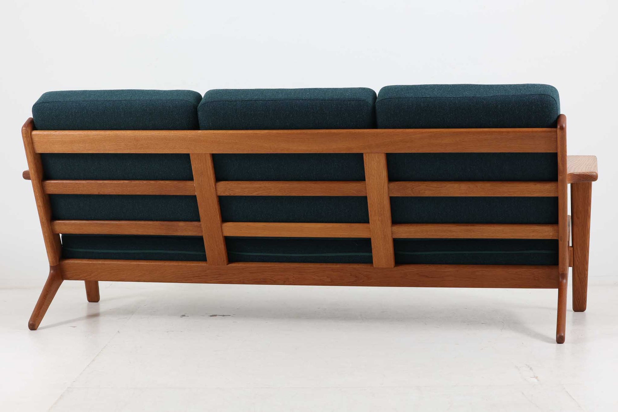 北欧家具を代表するソファ『GE290』です。現在リプロダクト品が販売されていますが、こちらは本物です。元々はベッド会社であるGETAmA社ならではのコイルスプリングが内包されたクッションの座り心地は、弾力があり心地良く、読書や映画などのリラックスタイムに最適です。立ち上がる際も適度なはね返りがあるので、動く時に億劫になる事はありません。HansJ.Wegnerならではの時代を超えた素晴らしいデザインです。横や背面から見るとまた違った表情を感じて頂けると思います。