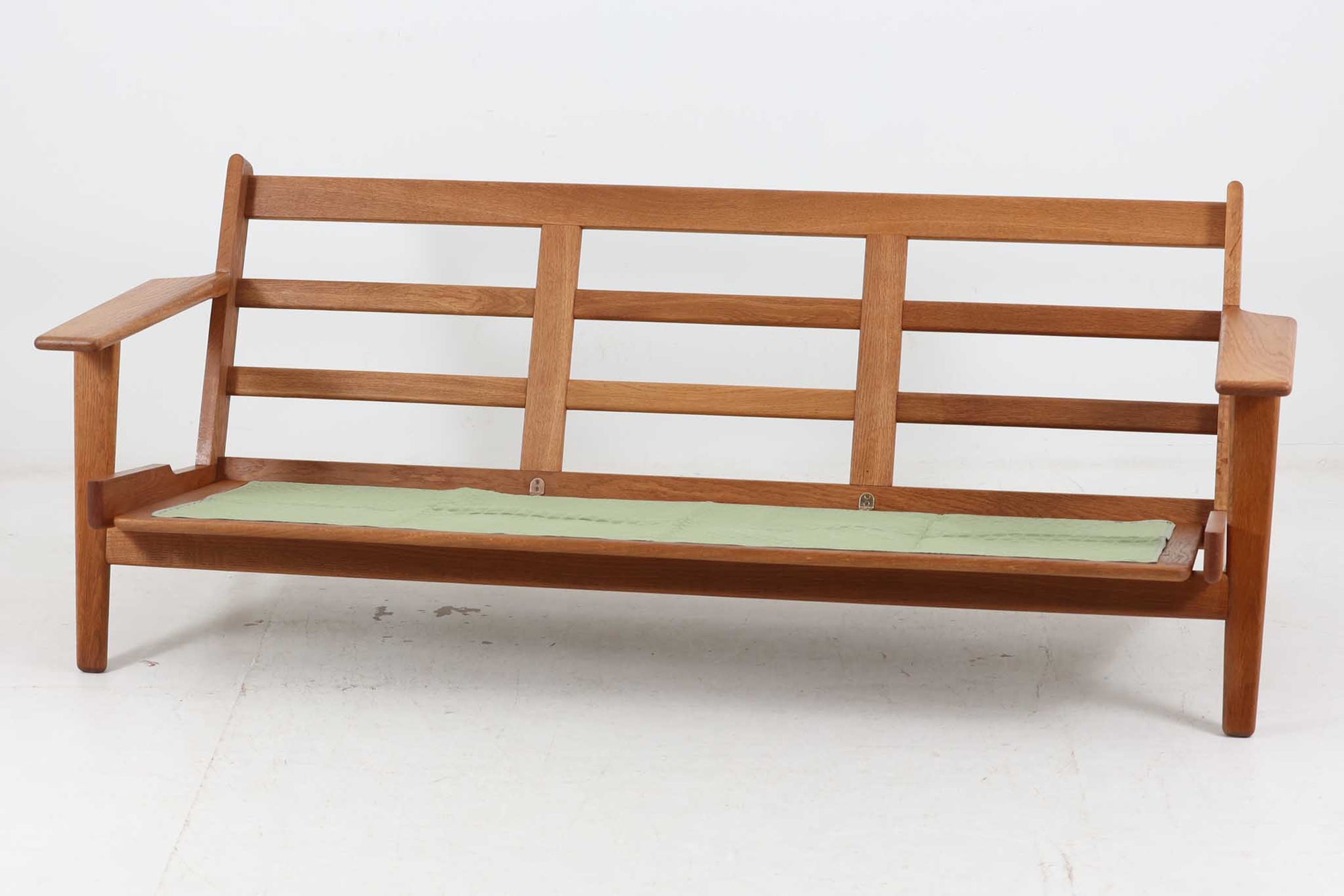 北欧家具を代表するソファ『GE290』です。現在リプロダクト品が販売されていますが、こちらは本物です。元々はベッド会社であるGETAmA社ならではのコイルスプリングが内包されたクッションの座り心地は、弾力があり心地良く、読書や映画などのリラックスタイムに最適です。立ち上がる際も適度なはね返りがあるので、動く時に億劫になる事はありません。HansJ.Wegnerならではの時代を超えた素晴らしいデザインです。横や背面から見るとまた違った表情を感じて頂けると思います。