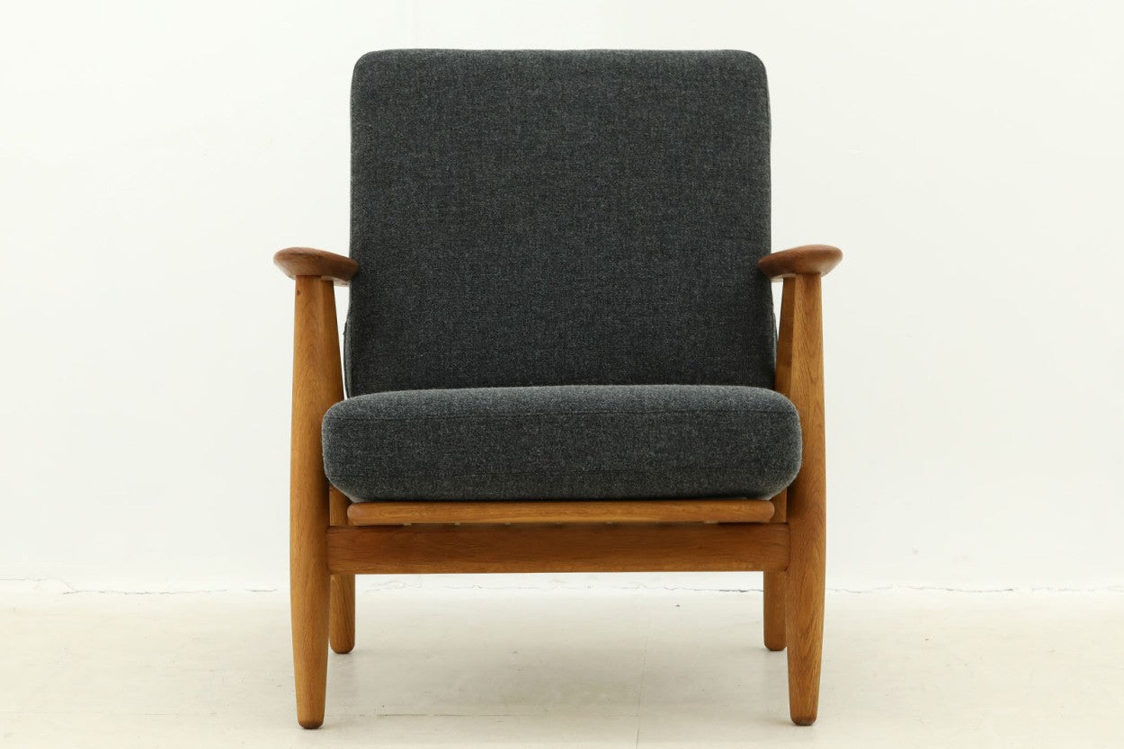 北欧家具を代表するソファ『GE240』です。現在ではビンテージ品のみ入手可能です。GE290のフレームより傾斜や曲線が多く使用されており、汚れやすいアーム部のみチーク材を使用するという手の込んだ作りを感じさせてくれます。元々はベッド会社であるGETAmA社ならではのコイルスプリングが内包されたクッションの座り心地は、弾力があり心地良く、読書や映画などのリラックスタイムに最適です。立ち上がる際も適度なはね返りがあるので、動く時に億劫になる事はありません。HansJ.Wegnerならではの時代を超えた素晴らしいデザインです。横や背面から見るとまた違った表情を感じて頂けると思います。アーム部にチーク材が使用された希少なモデルです。