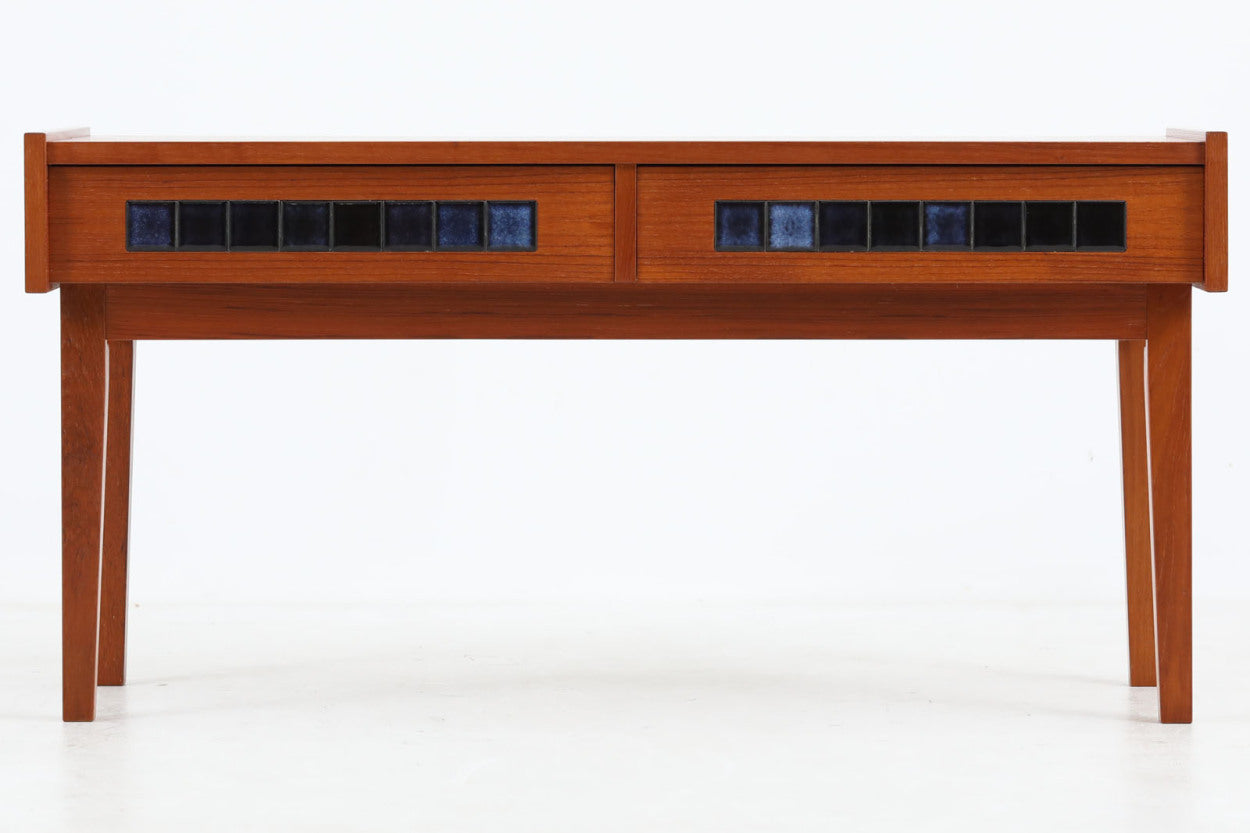 こちらは、北欧より買い付けたワイドチェストです。優れた品質のチーク材を本体に使用し、引き出し前板には鮮やかなブルーのタイルが施されており、デザインのアクセントとなっています。また、左右に取り付けられた細身のテーパー脚が、全体に洗練された印象を与えています。幅90cmのワイドサイズなので、ローボードやセンターテーブルとしてもお使いいただけます。